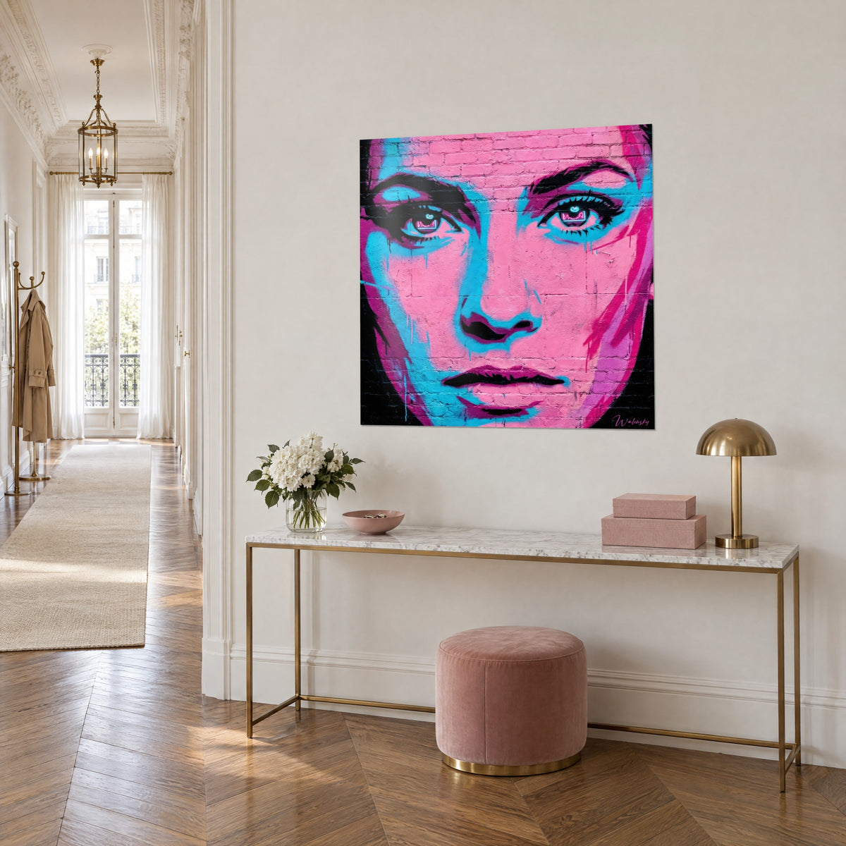 Cuadro rostro de mujer pintado con aerosol, mejillas rosas, sombras cian, labios negros, sobre una consola dorada, vista de tres cuartos