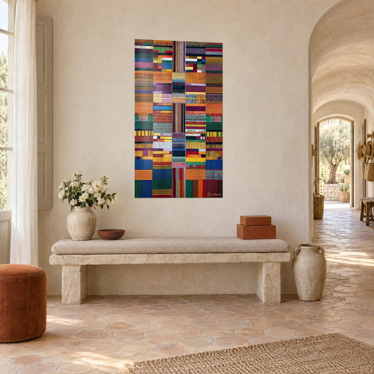 Cuadro mosaico de telas kente con rayas ocre, burdeos y turquesa, visto de tres cuartos en el mas, banco de piedra