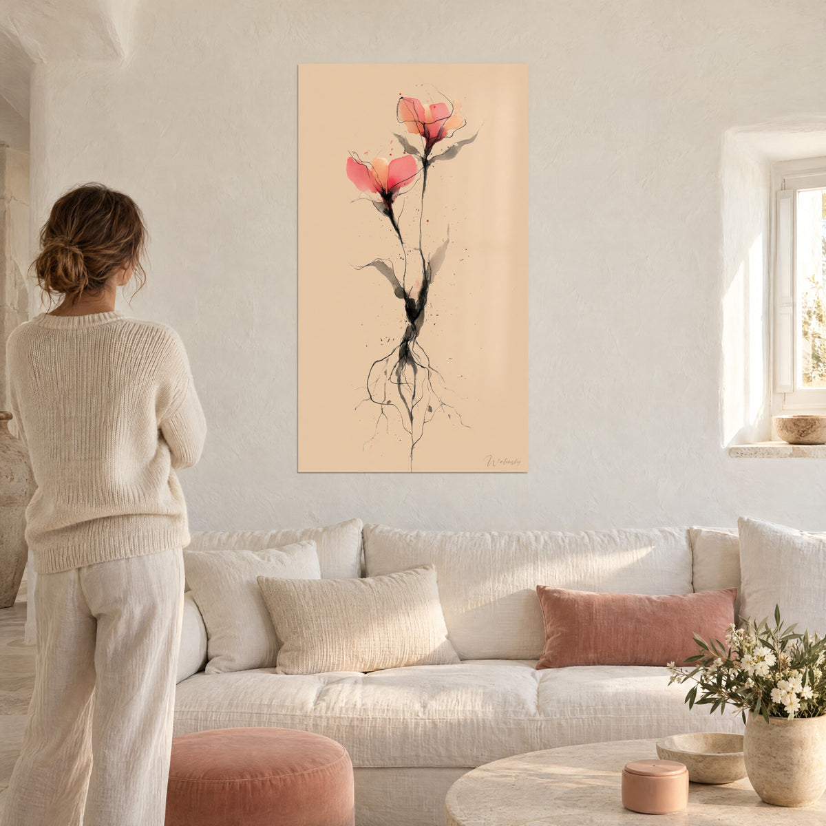 Cuadro de una delicada flor rosa con pétalos coral y tallo negro, sobre fondo beige, encima de un sofá en un salón luminoso