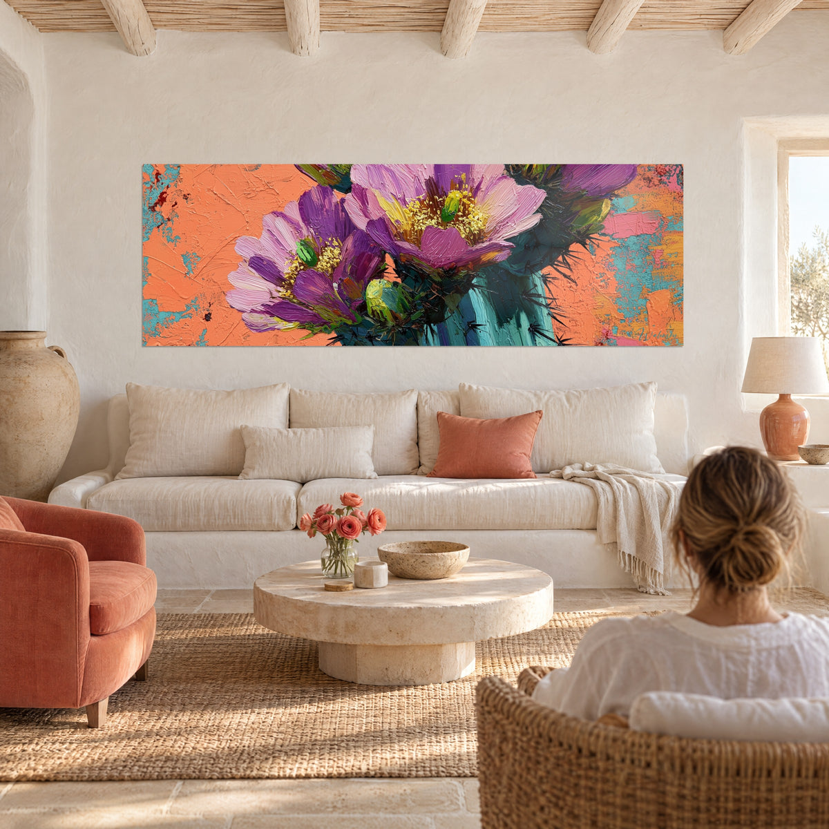Schilderij cactusbloei, paarse bloemblaadjes en gele hartjes op een koraalkleurige achtergrond, boven een bank in een lichte woonkamer