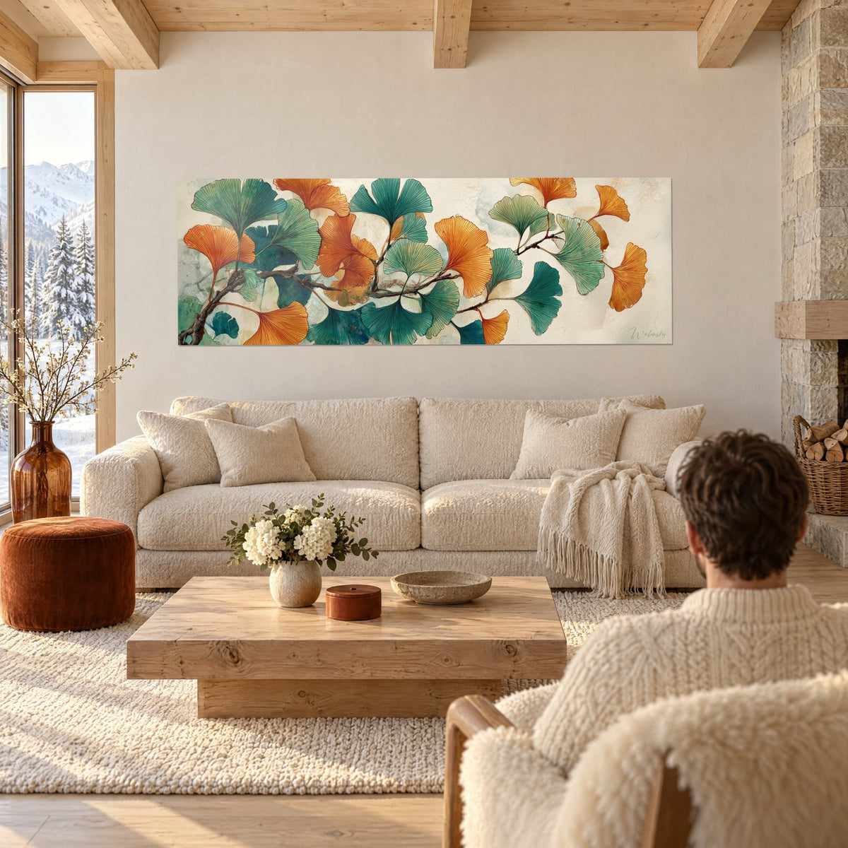 Tableau éventails de ginkgo orange et turquoise sur branche brune, deux personnes de dos, au-dessus d'un canapé dans un salon lumineux