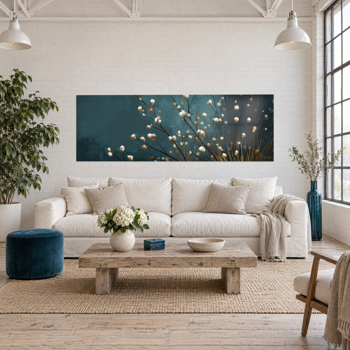 Wall art with thin stems and white and golden pompoms on a blue-green background, hung above a sofa in a bright living room