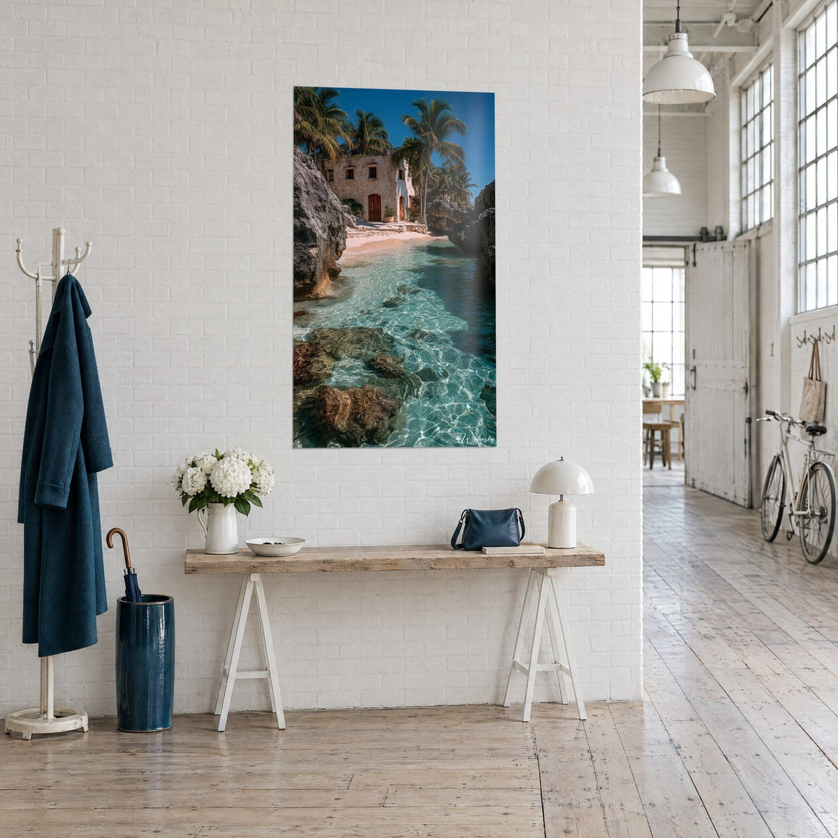 Wall art of a secret paradise with pink sand and grey rocks, arched wooden door beneath palm fronds, three-quarter view in an artist's loft