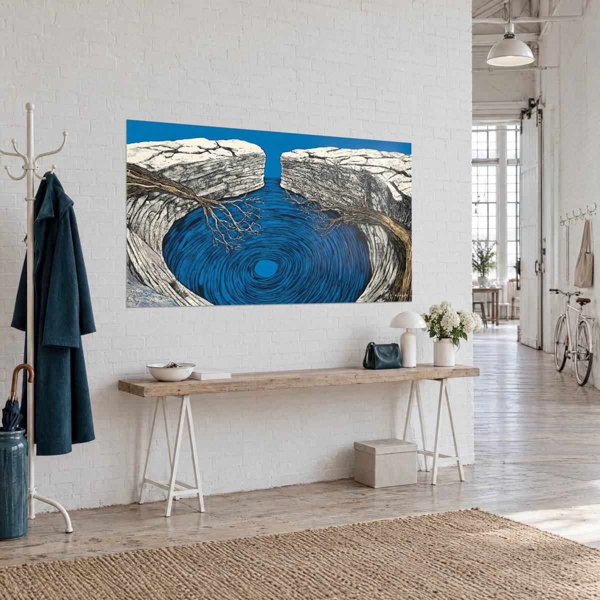 Tableau vortex d'eau indigo creusé dans la roche blanche, branches brunes dénudées, accroché sur un mur de brique blanche de loft