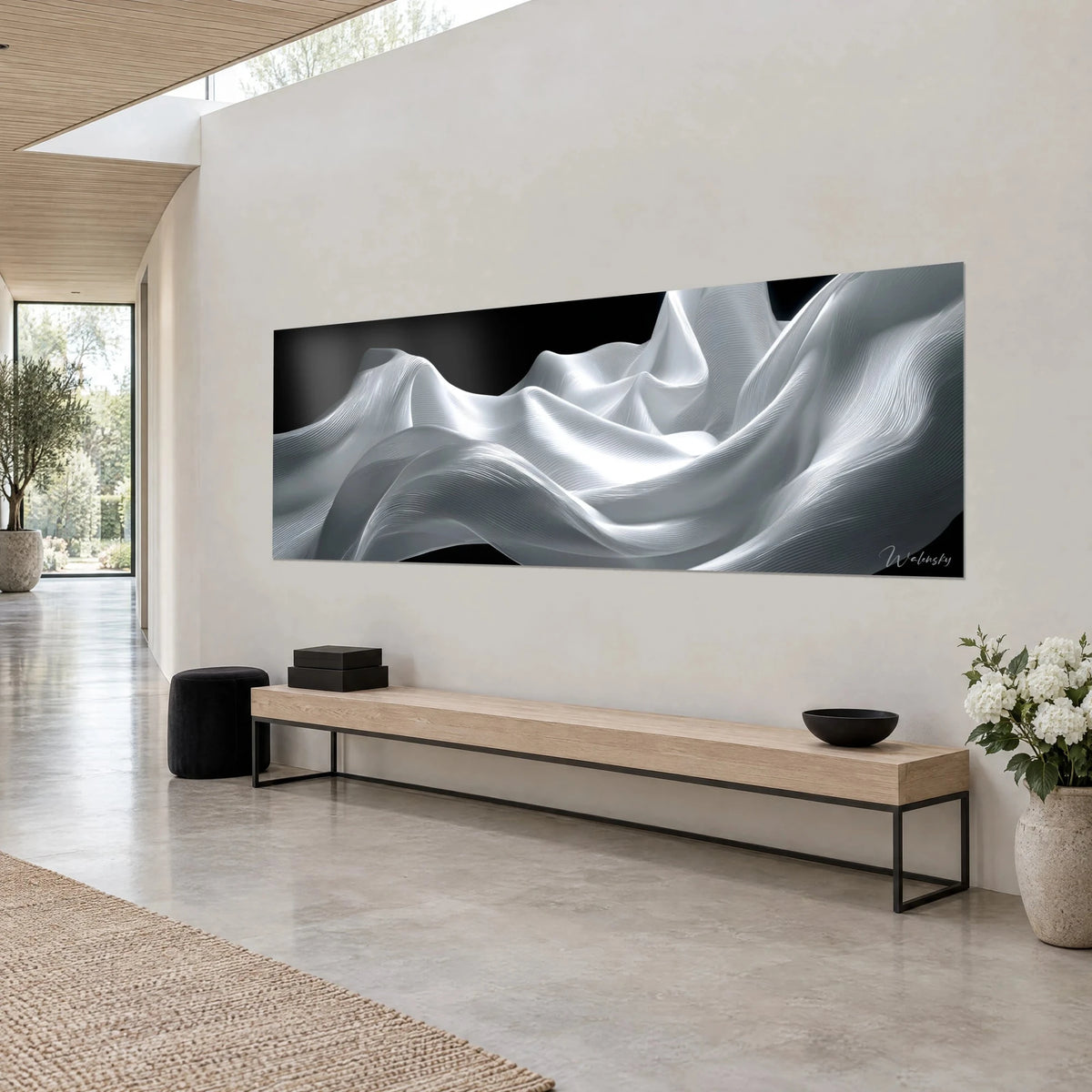 Cuadro de olas de tela nacarada con estrías finas, blanco brillante y negro profundo, sobre una pared beige encima de un banco de madera