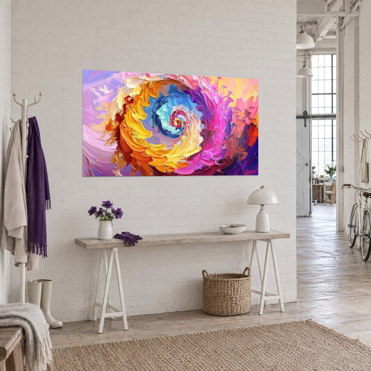 Tableau vortex à la spatule orange, violet et turquoise, œil bleu au centre, sur mur blanc au-dessus d'une console en bois