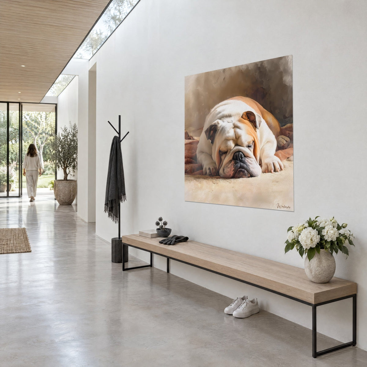 Wall art of a dog with drooping jowls, ivory and caramel coat, lying on a throw, white wall of a glass-walled hallway