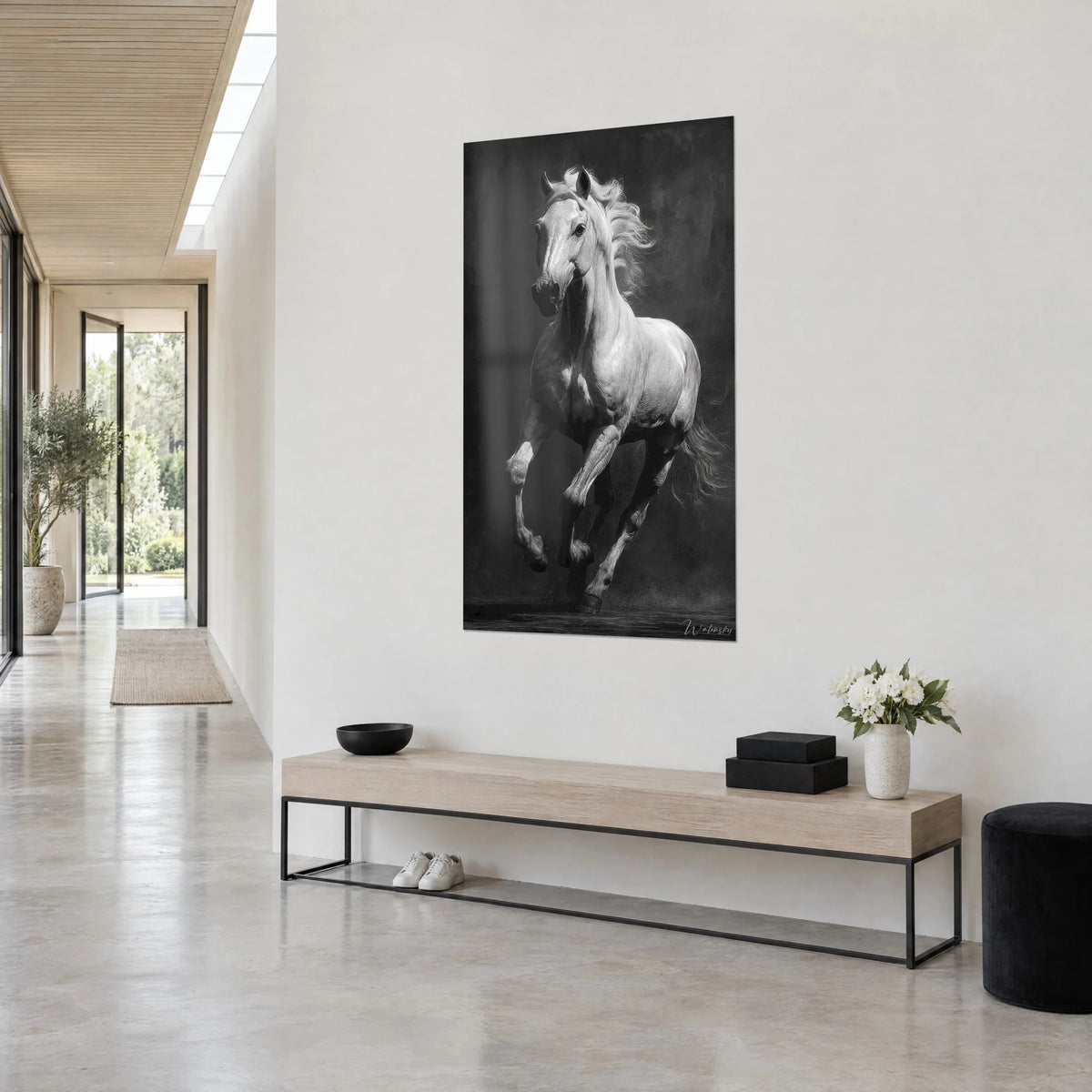 Wall art pearl grey stallion in full stride, anthracite background, on a white entrance wall, light wood bench and white flowers