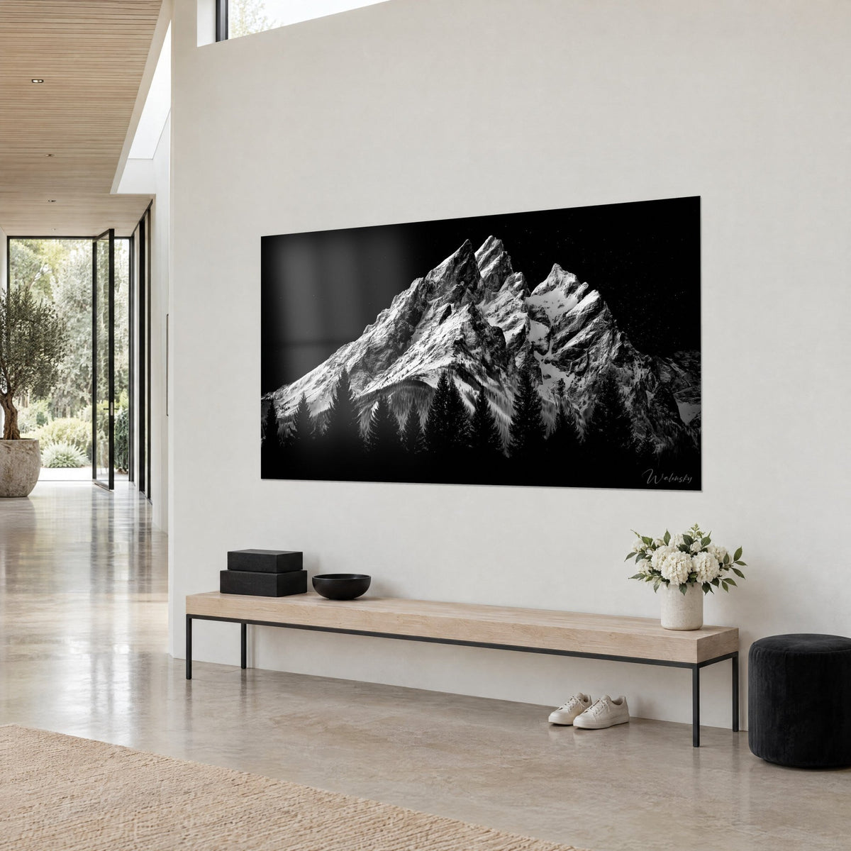 Tableau cimes acérées blanc argenté sur ciel noir étoilé, vue de trois-quarts sur un mur crème, banc en bois clair