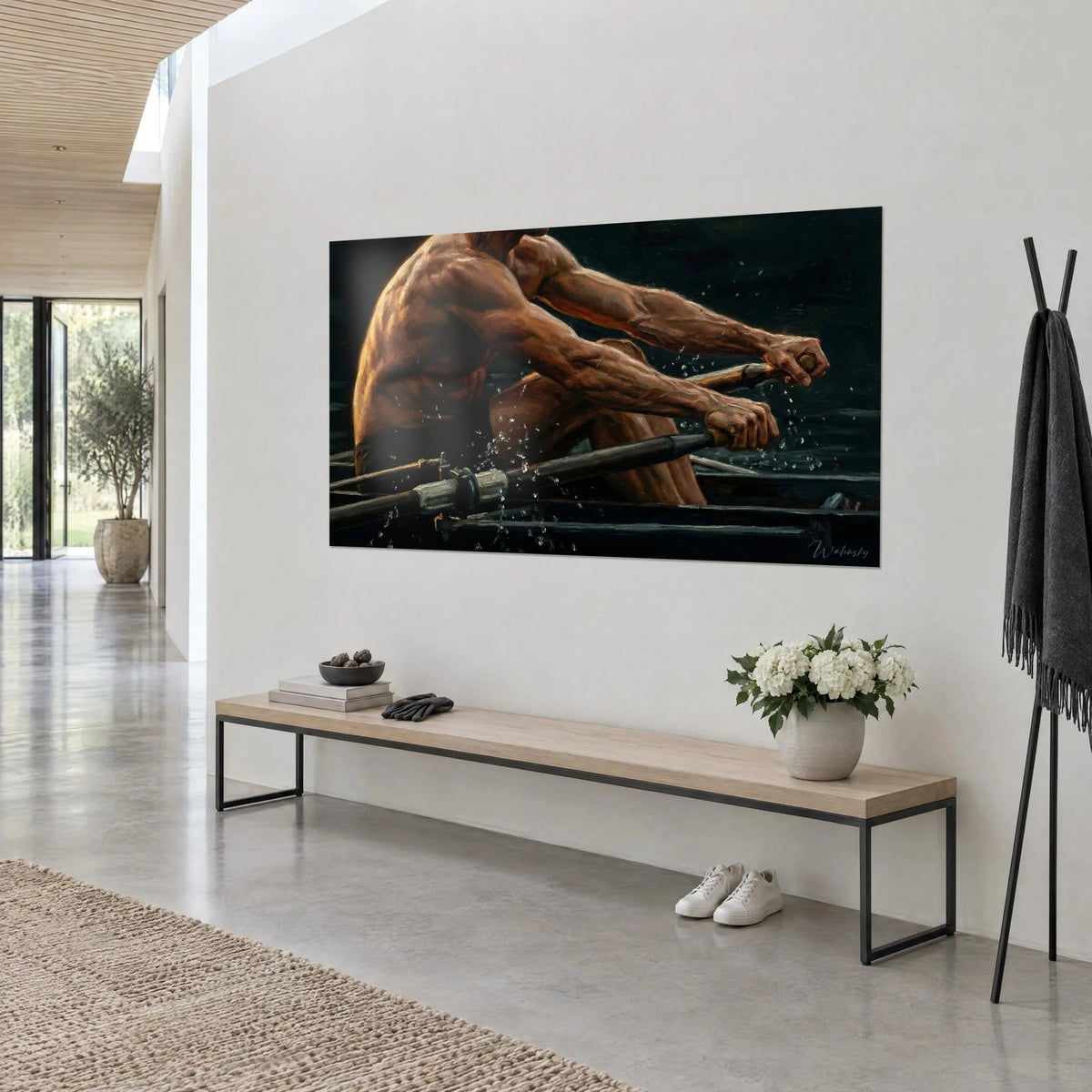 Wall art of an athlete mid-effort, bronze back and dark brown oars, suspended water droplets, hung in a bright hallway