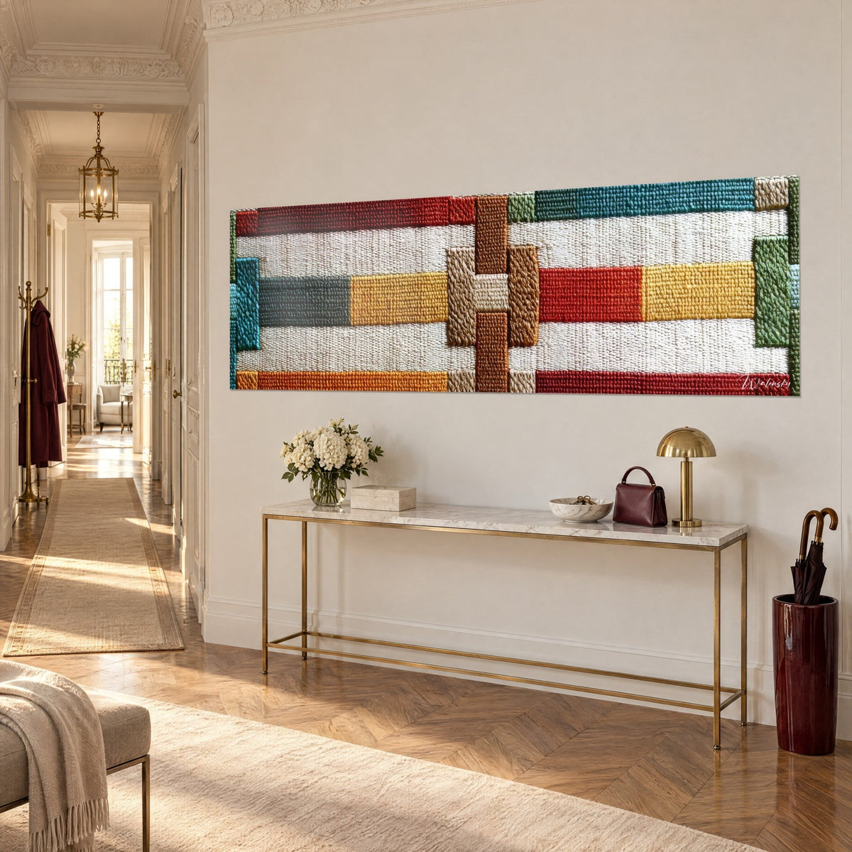 Wall art mosaic of woven rectangles in brick red, mustard yellow and fir green, three-quarter view, above a gilded console in the entrance hall