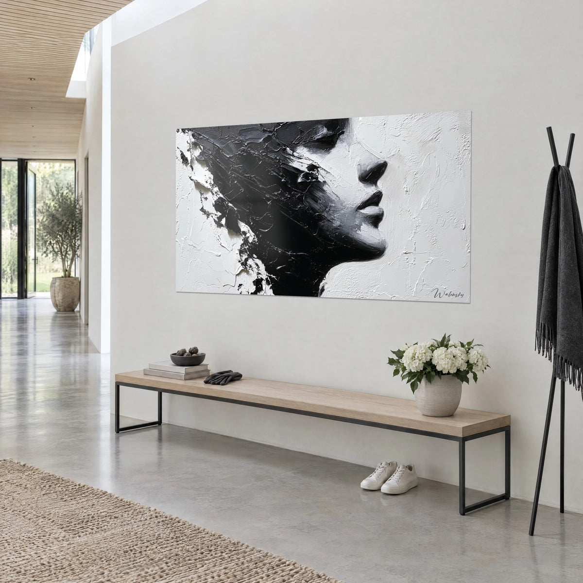 Quadro volto femminile di profilo, pennellate a spatola nero inchiostro e bianco gesso, labbra scure, appeso sopra una panca in legno