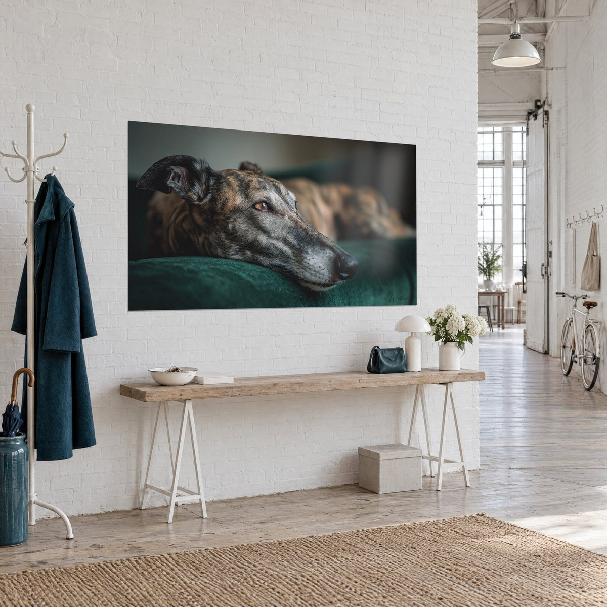 Wall art long-legged dog with brown and grey brindle coat, amber gaze, emerald cushion, three-quarter view on a wooden console