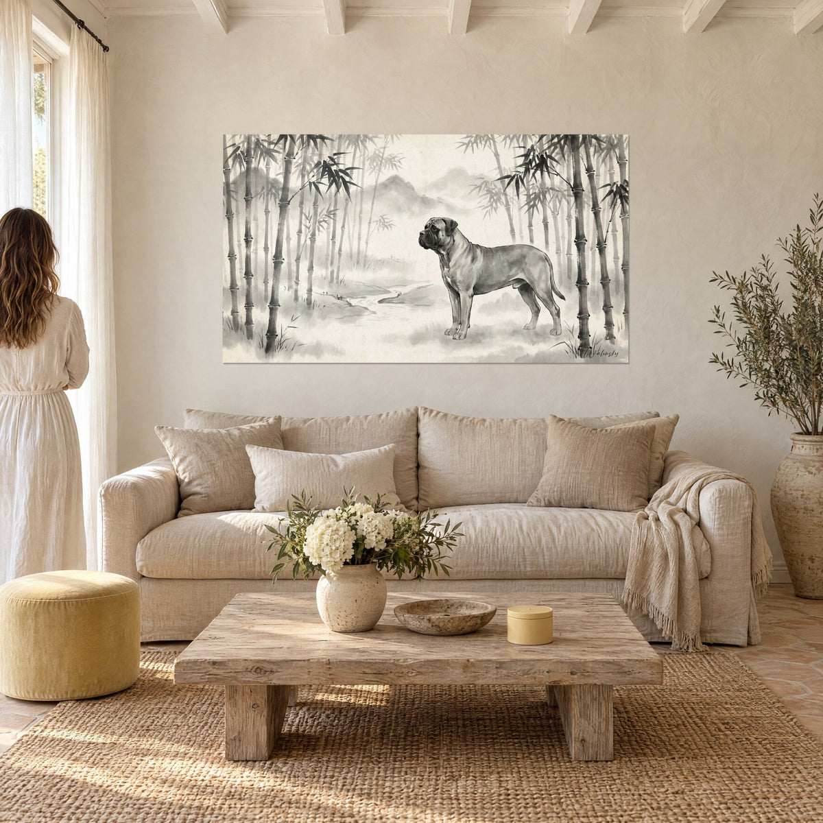 Wall art Bullmastiff in profile within a bamboo grove in grey and ivory ink, on a beige wall, person seen from behind, above a sofa in a bright living room
