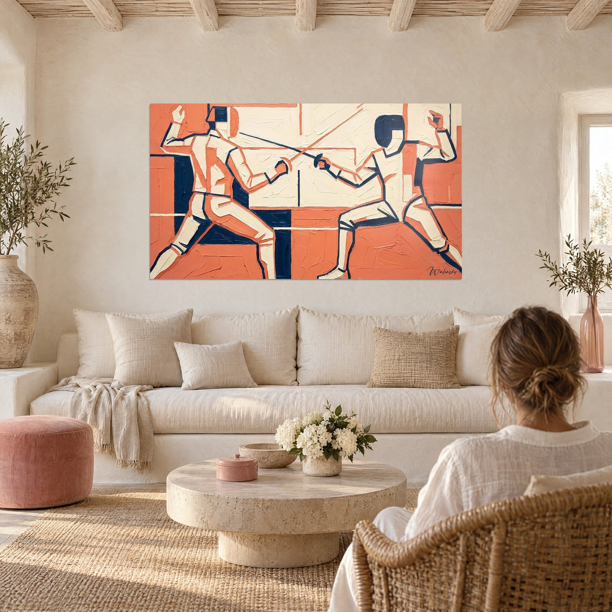 Wall art of a fencing duel in coral orange and midnight blue, two stylized fencers, above a sofa in a bright living room