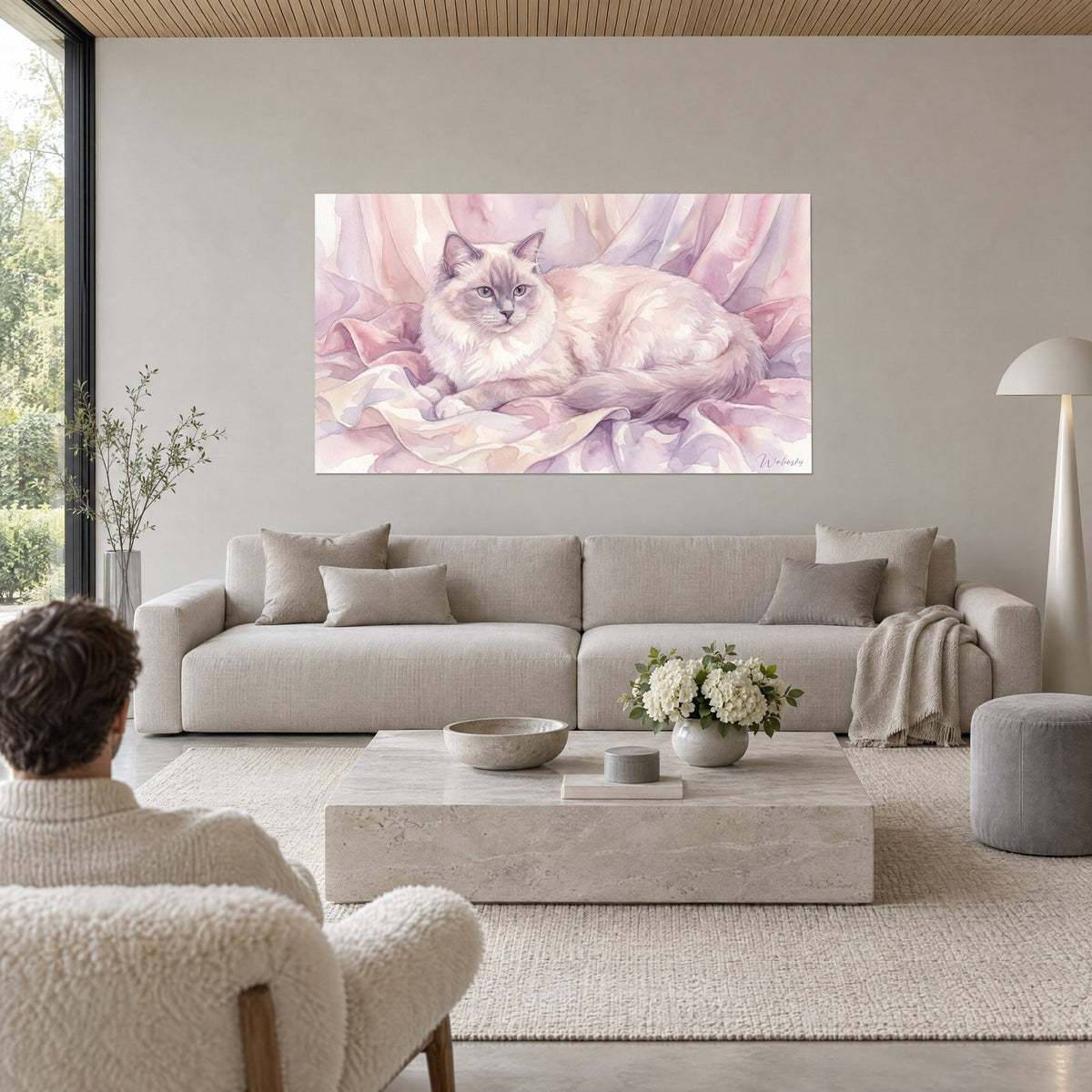 Quadro gatto ragdoll dal manto crema e toni rosa cipria, occhi azzurri, su drappi lilla sopra un divano in un soggiorno luminoso