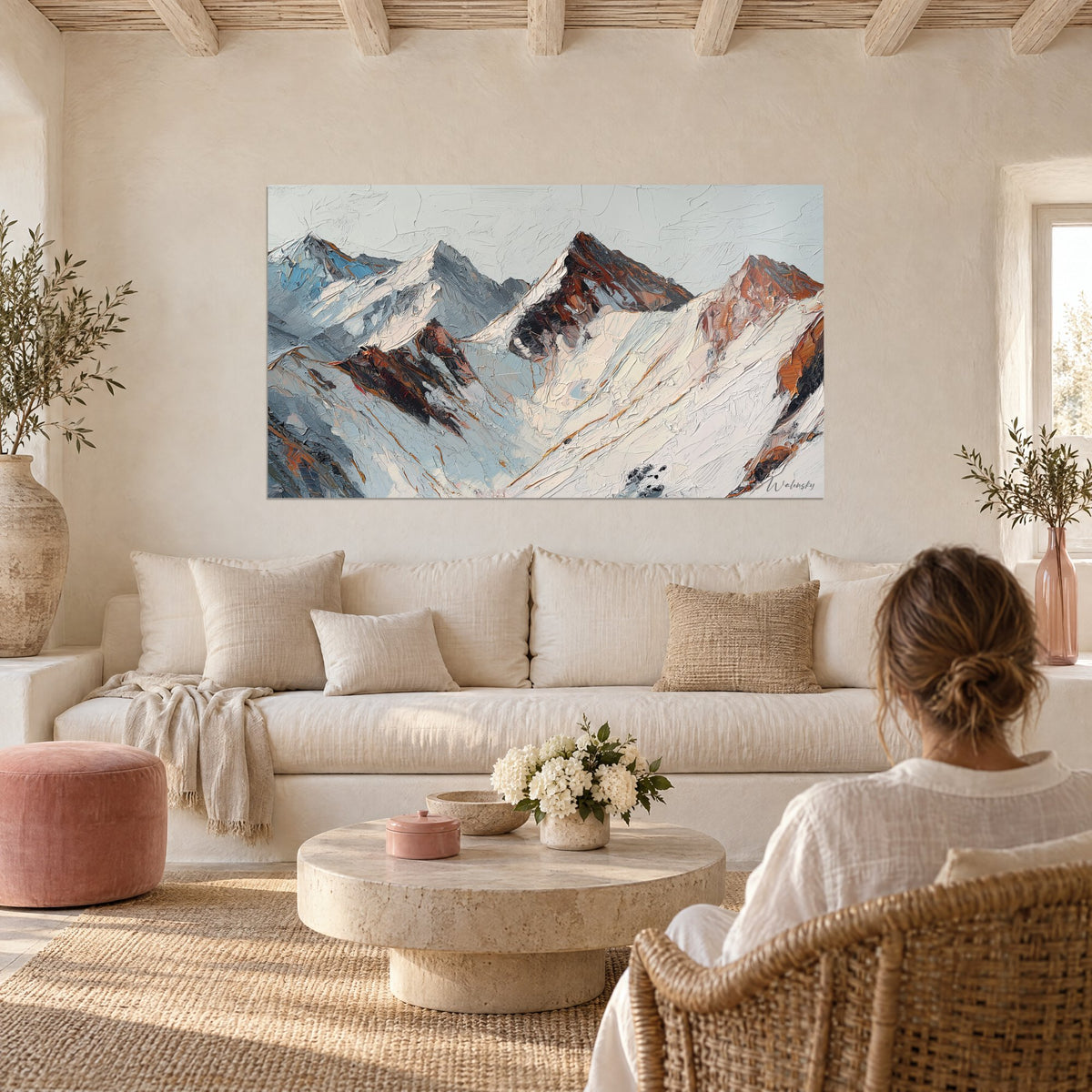 Tableau cimes pyrénéennes poudrées de neige, roches rousses et ciel gris pâle, au-dessus d'un canapé dans un salon lumineux