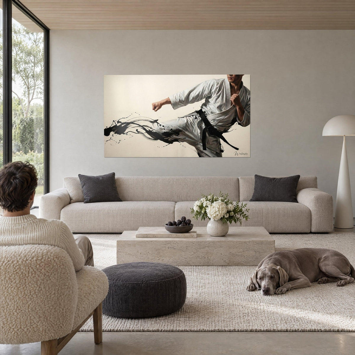 Tableau karatéka en kimono blanc lançant un coup de pied, ceinture noire et encre noire, au-dessus d'un canapé dans un salon lumineux