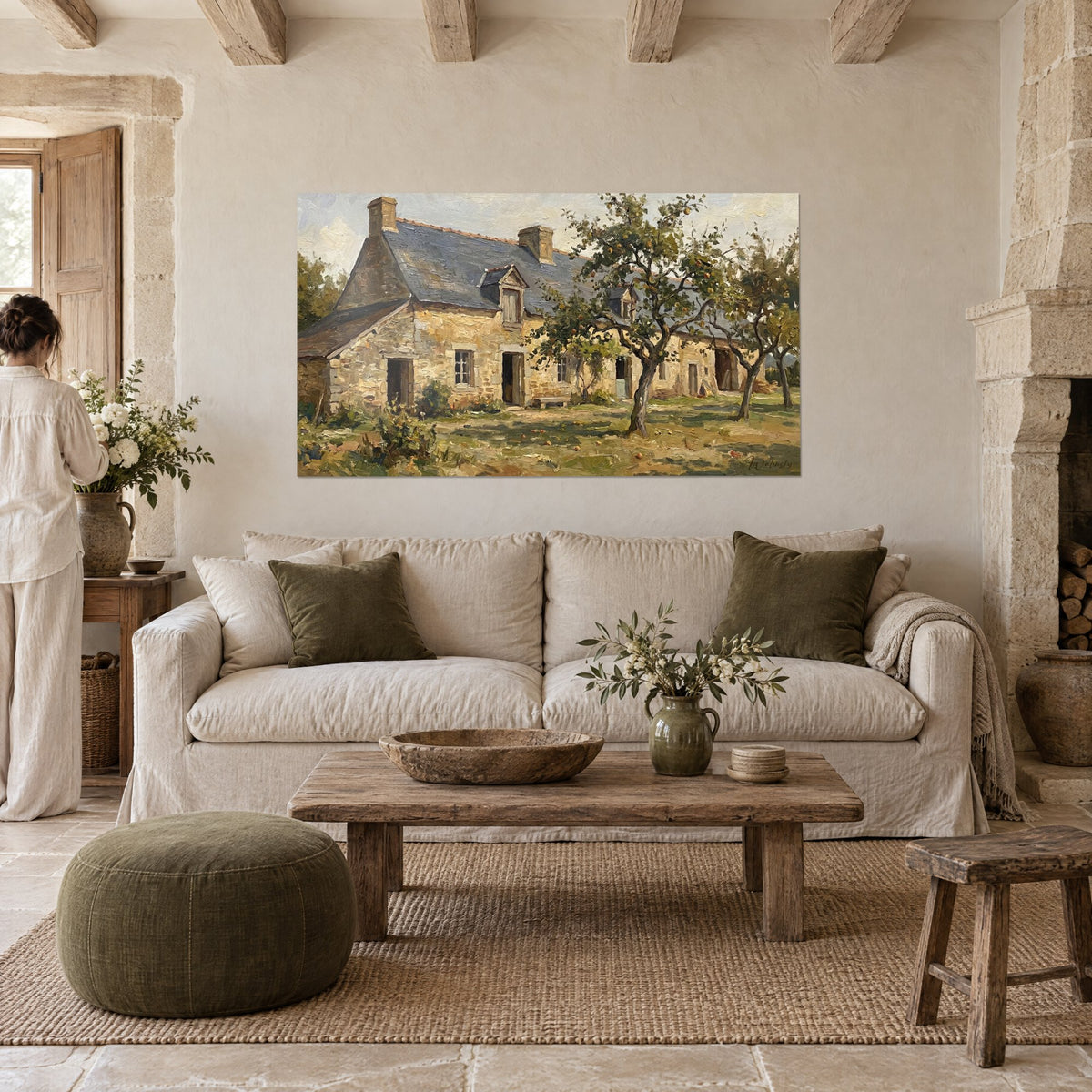 Wall art of a Norman stone farmhouse in golden stone, blue-grey slate roof and apple trees heavy with fruit, above a sofa in a bright living room