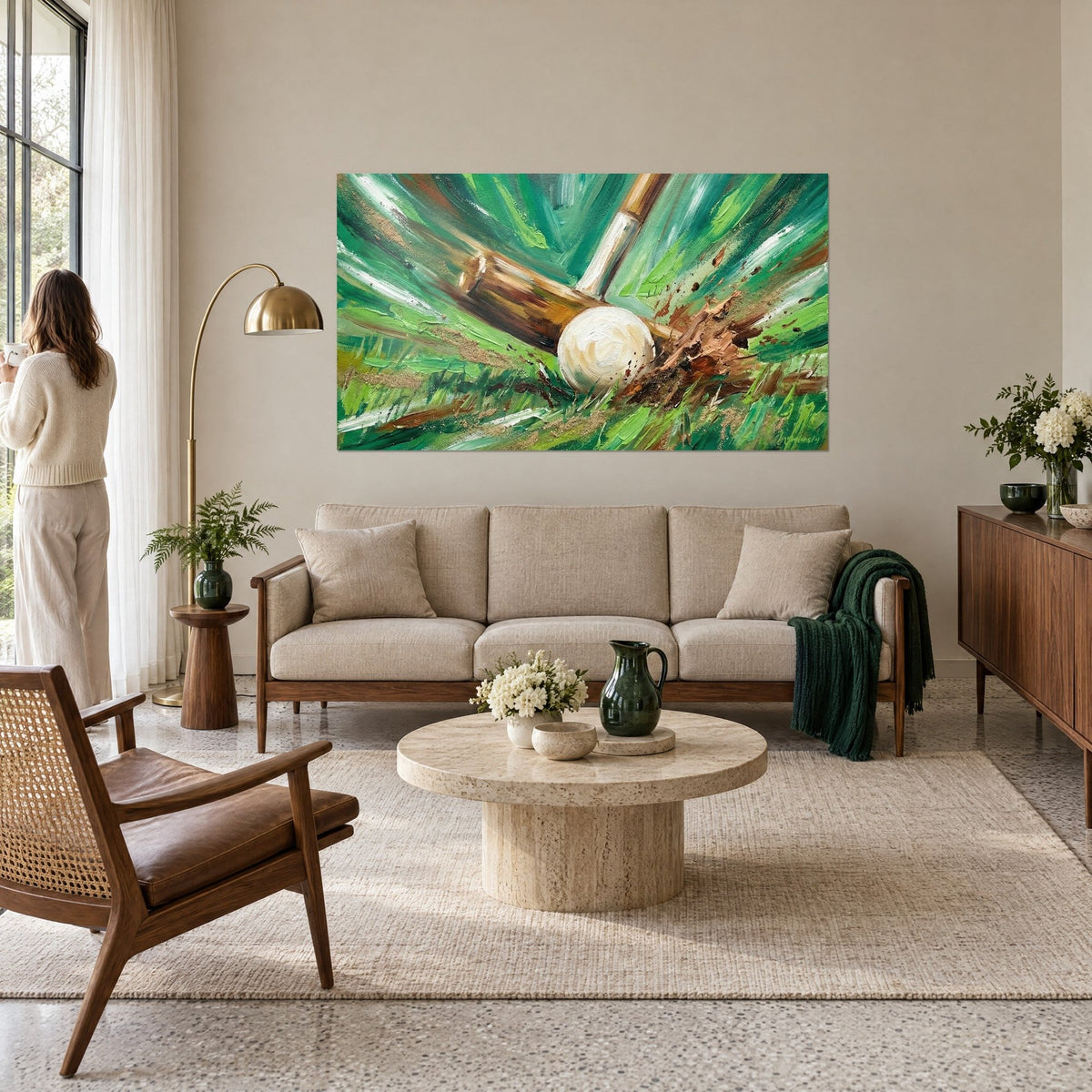 Wall art polo mallet slicing through the grass, ivory ball and brown flecks of earth, hung above a sofa in a bright living room