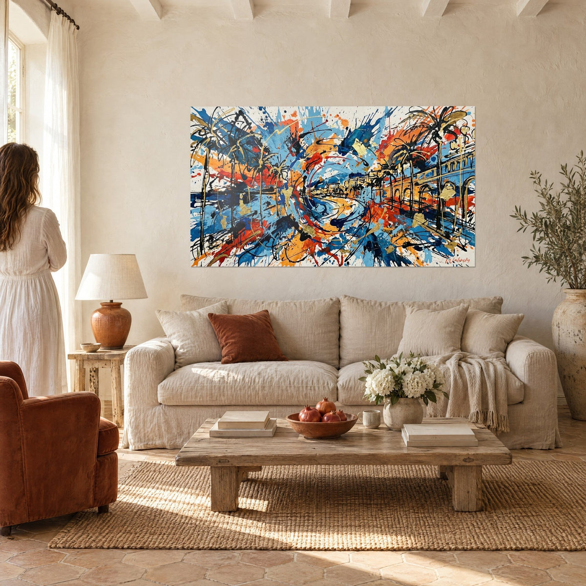 Wall art Promenade des Anglais burst in cobalt blue and orange, black palm trees and gold leaf, hung above a sofa in a bright living room