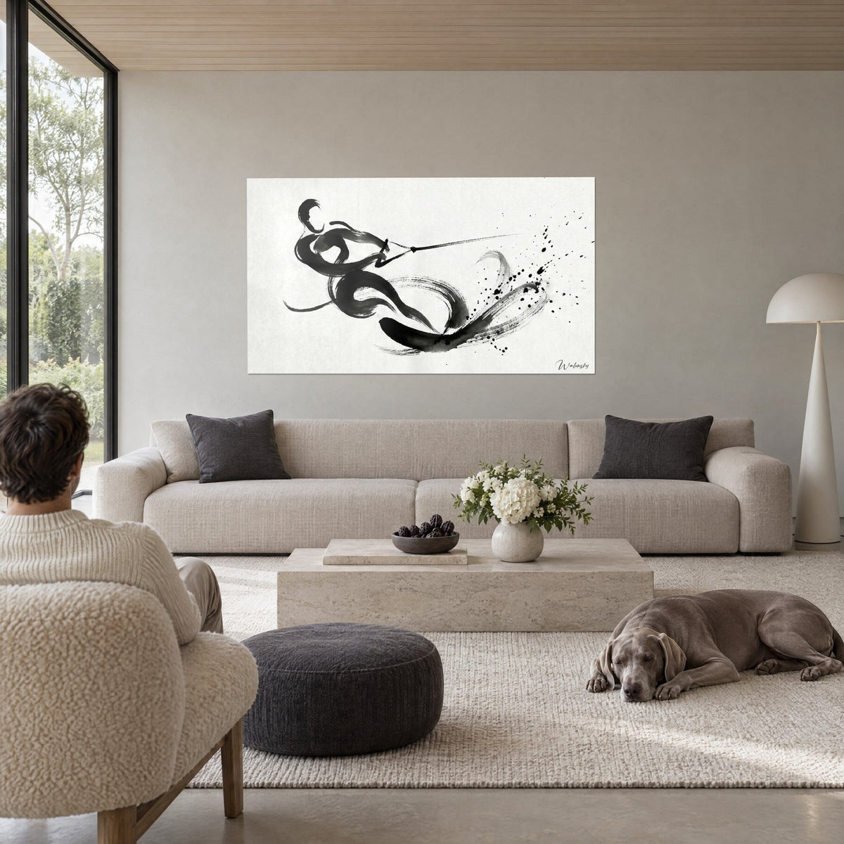 Quadro di uno sciatore nautico in inchiostro nero che taglia l'onda, tratto calligrafico su fondo crema, sopra un divano in un soggiorno luminoso