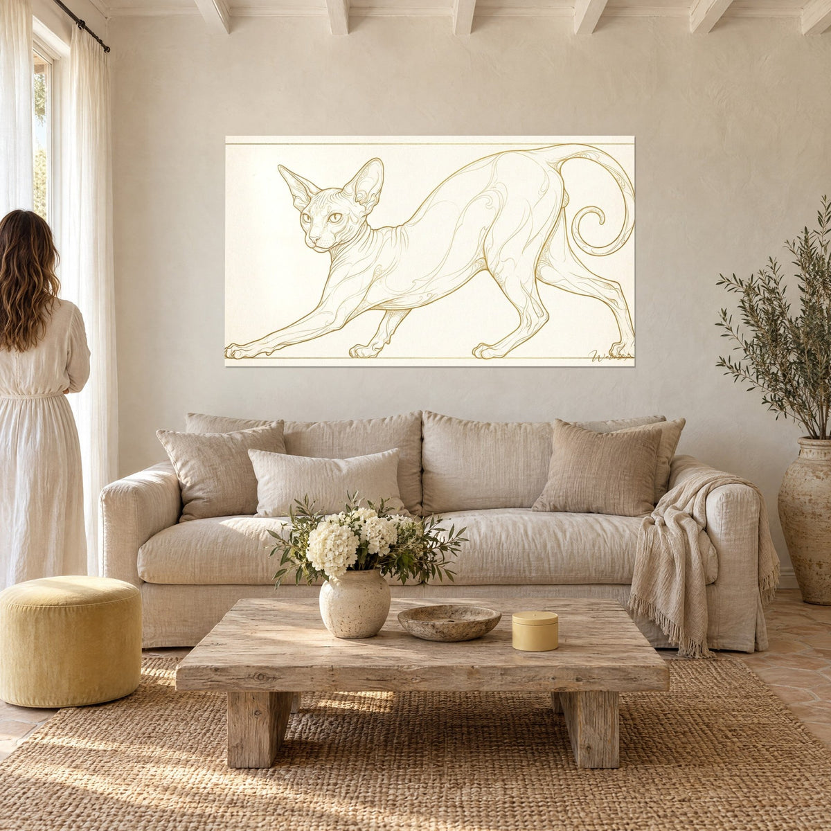 Schilderij sphynxkat die zich uitrekt met gouden lijnen op een crèmekleurige achtergrond, stel van achteren, boven een bank in een lichte woonkamer