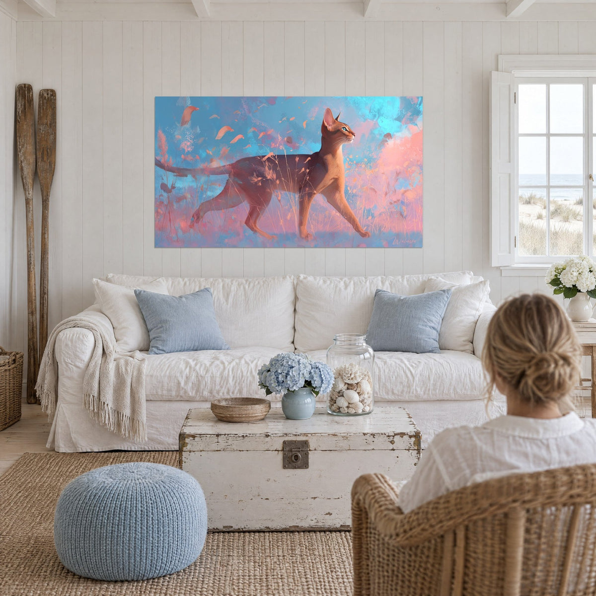 Tableau chat abyssin au pelage cuivré marchant parmi des herbes rose pâle sur fond bleu ciel, au-dessus d'un canapé dans un salon lumineux