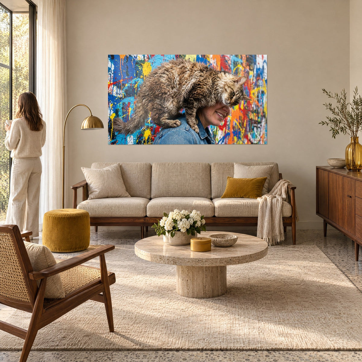 Quadro gatto Laperm dal pelo riccio marrone e crema sulla spalla di una donna in jeans, sfondo schizzato di blu e arancio, sopra un divano in un soggiorno luminoso