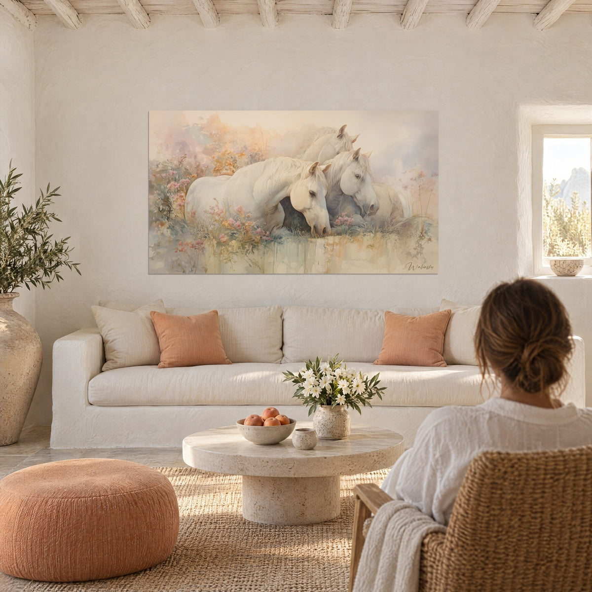 Gemälde drei dicht beieinander stehende weiße Pferde zwischen rosa Blüten, Aquarell in Ocker und Lavendel, über einem Sofa in einem hellen Wohnzimmer