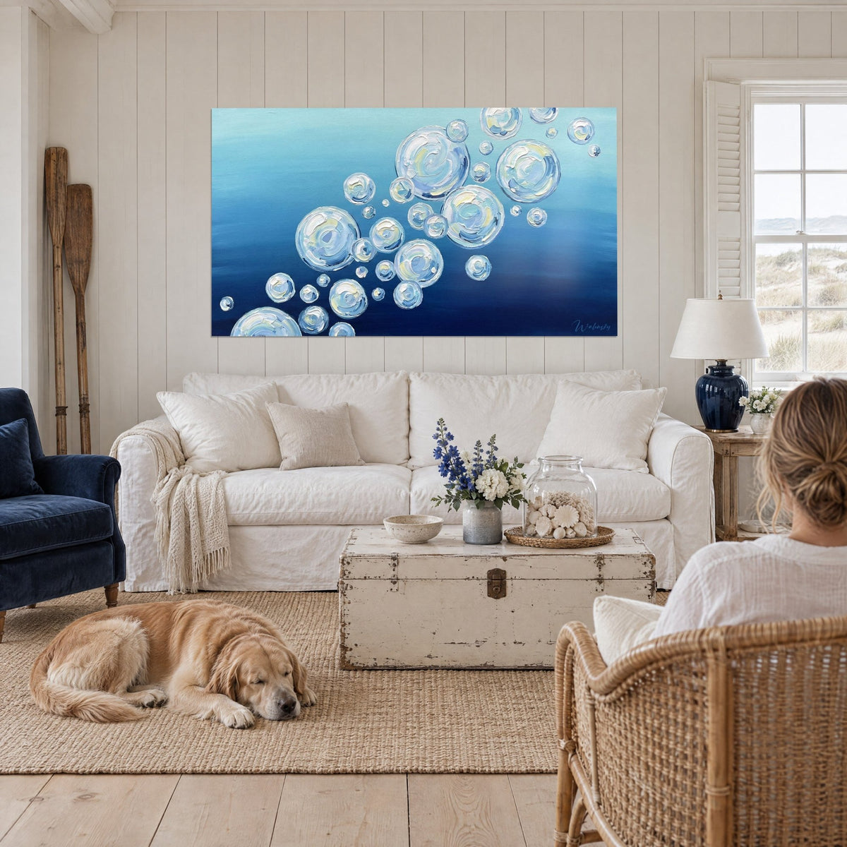 Schilderij transparante bellen in dikke verf, marineblauw en turquoise, boven een bank in een lichte woonkamer