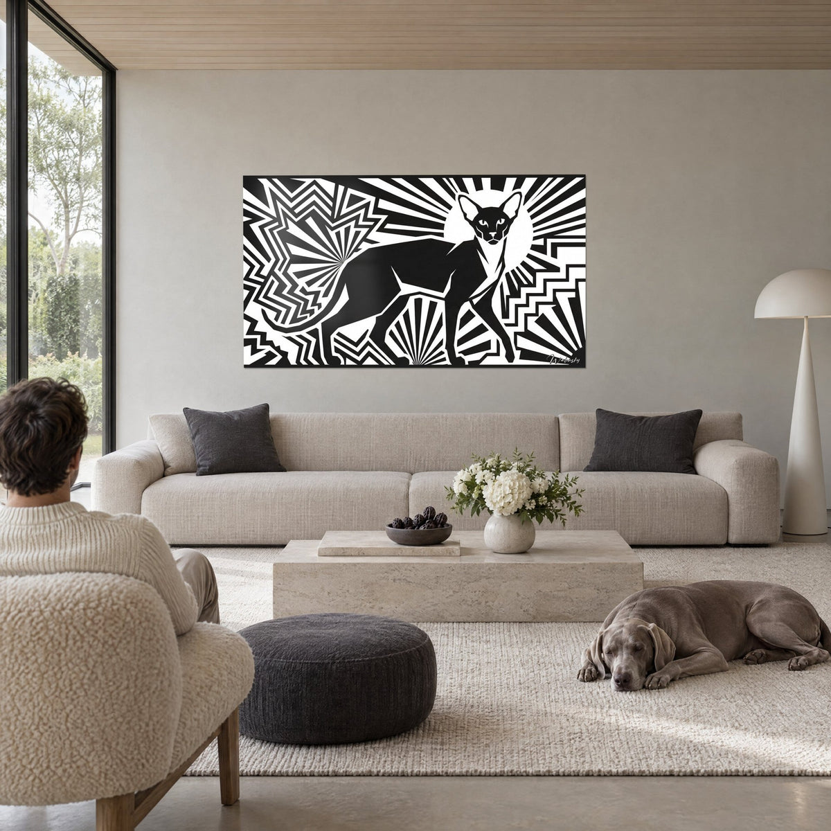Tableau chat oriental noir de profil, rayons blancs en éventail, deux personnes et un Weimaraner, au-dessus d'un canapé dans un salon lumineux