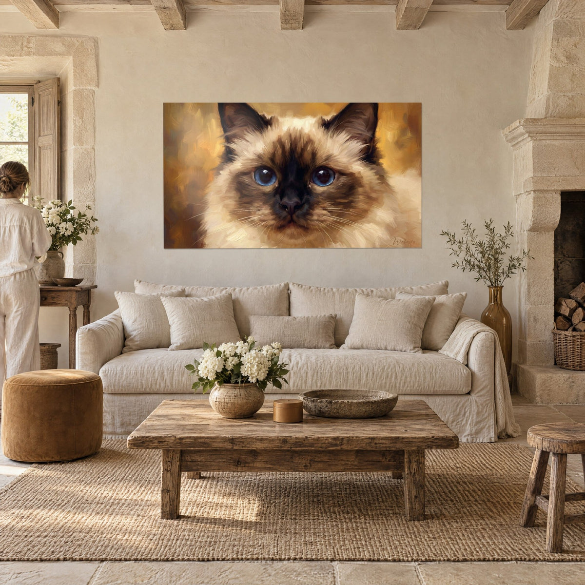Schilderij Birmaanse kat met doordringend blauwe ogen, crème en okerkleurige vacht, boven een bank in een lichte woonkamer