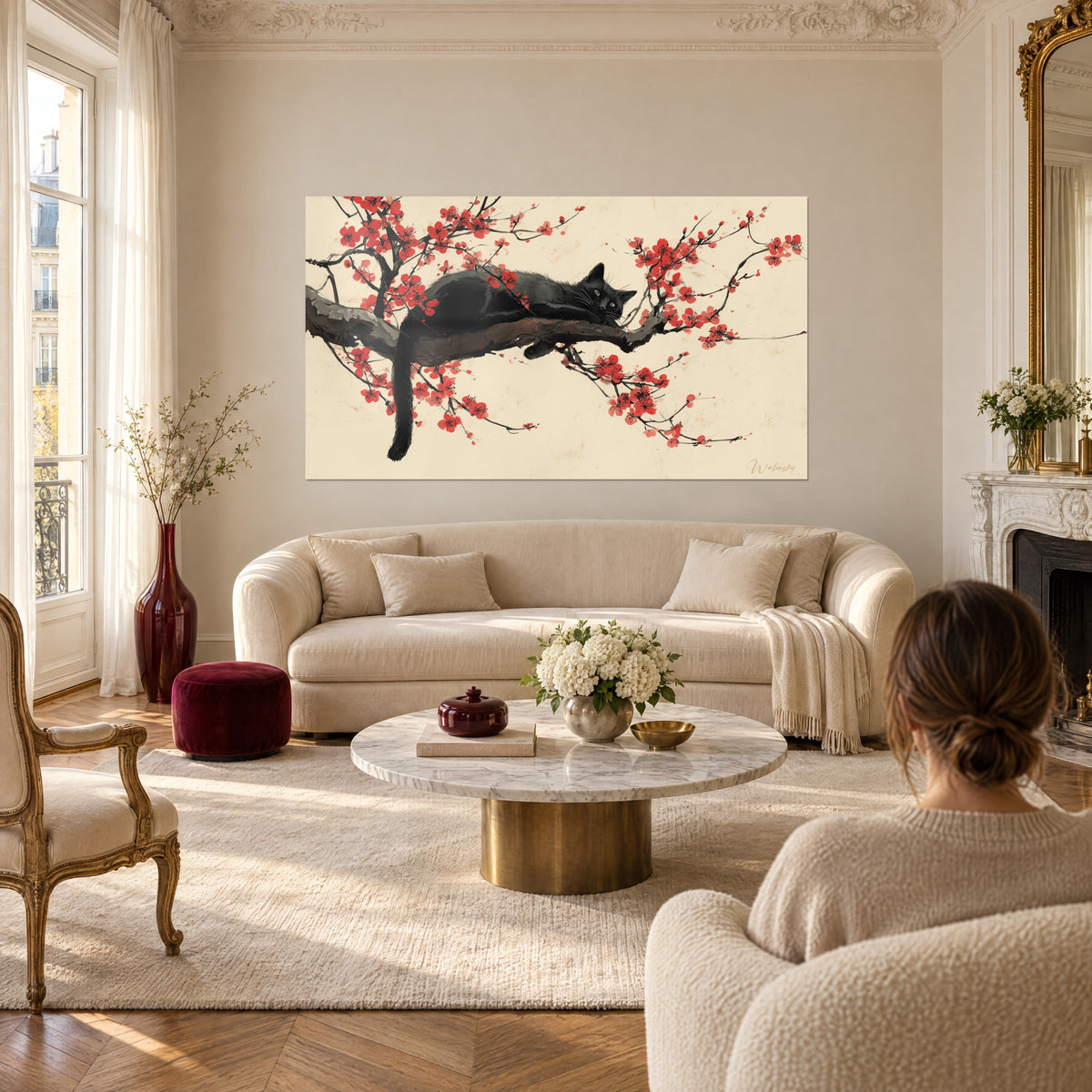 Cuadro gato negro tumbado sobre una rama de ciruelo con flores rojas, fondo crema, encima de un sofá en un salón luminoso