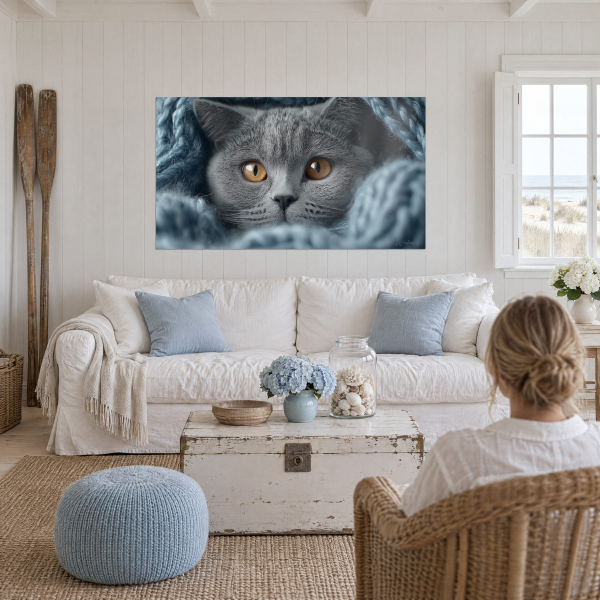 Πίνακας γάτα British shorthair με γκρι τρίχωμα και κεχριμπαρένια μάτια, κουλουριασμένη σε μπλε μάλλινη κουβέρτα, πάνω από καναπέ σε φωτεινό σαλόνι