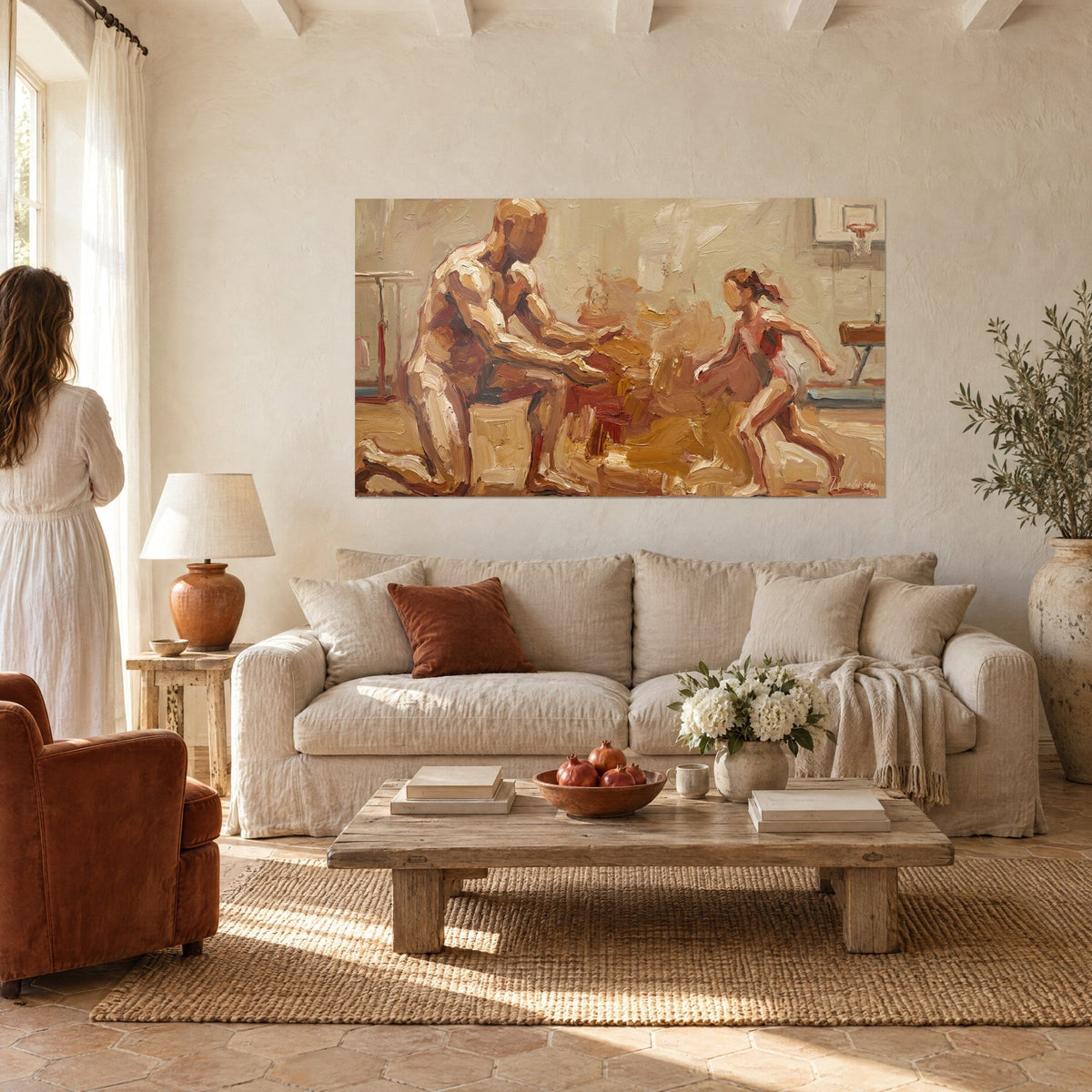 Wall art of a kneeling athlete reaching out to a gymnast in a pink leotard, ochre and rust tones, above a sofa in a bright living room