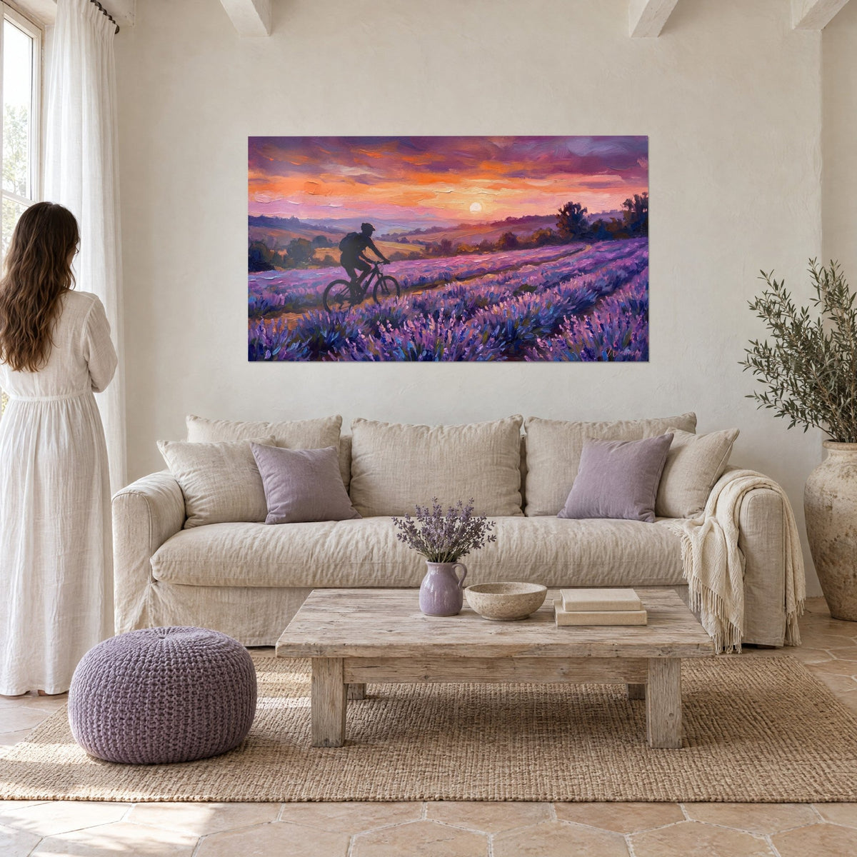 Wall art cyclist in dark silhouette on a purple trail, orange sun above a sofa in a bright living room