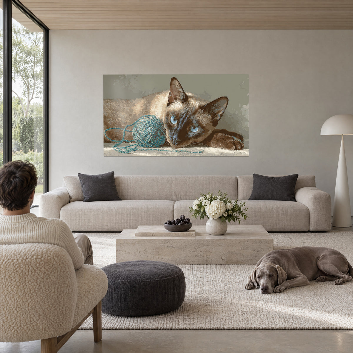 Πίνακας γάτα Tonkinese με γαλάζια μάτια ξαπλωμένη δίπλα σε τυρκουάζ μπάλα μαλλιού, κρεμ και καφέ τρίχωμα, πάνω από καναπέ σε φωτεινό σαλόνι