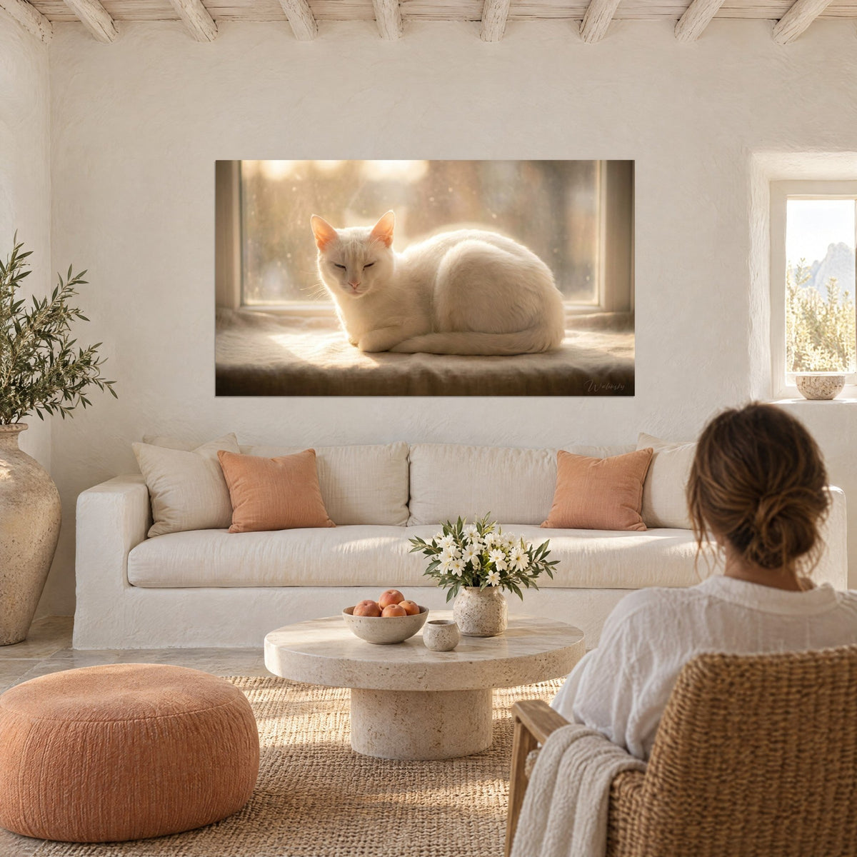 Tableau chat blanc lové sur un rebord de fenêtre, lumière dorée et ocre, femme de dos, au-dessus d'un canapé dans un salon lumineux
