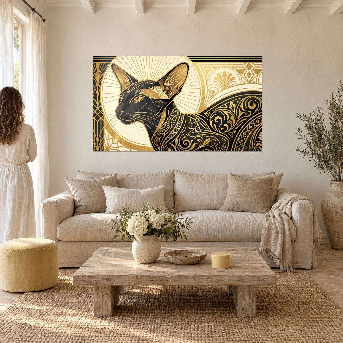 Tableau chat oriental noir aux oreilles dressées, motifs Art Déco or et crème, deux personnes de dos, au-dessus d'un canapé dans un salon lumineux