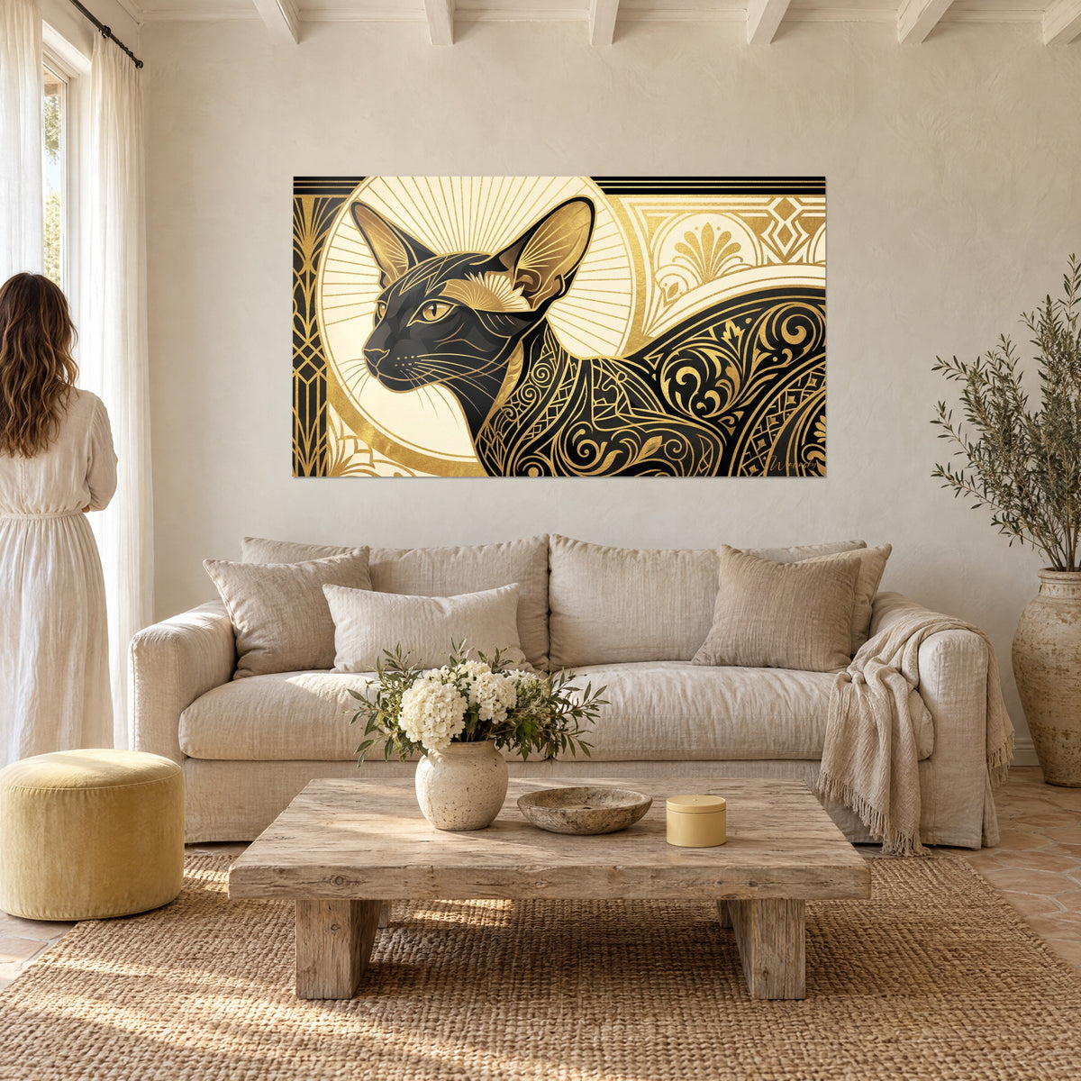 Πίνακας μαύρης γάτας Oriental Shorthair με όρθια αυτιά, διακοσμητικά μοτίβα Art Deco σε χρυσό και κρεμ, δύο άτομα από πίσω, πάνω από καναπέ σε φωτεινό σαλόνι