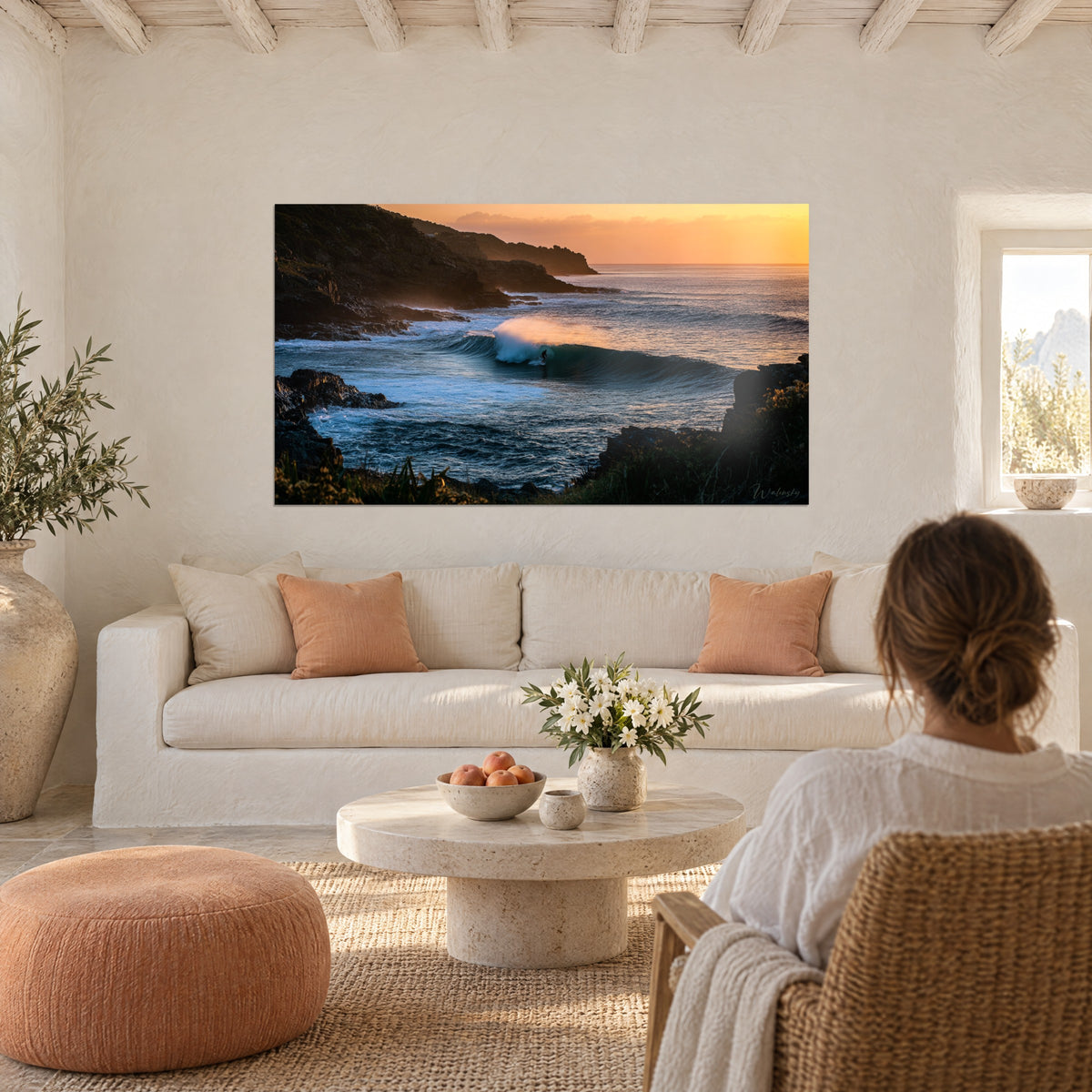 Tableau surfeur glissant dans le tube d'une vague, falaises sombres et ciel orangé, au-dessus d'un canapé dans un salon lumineux