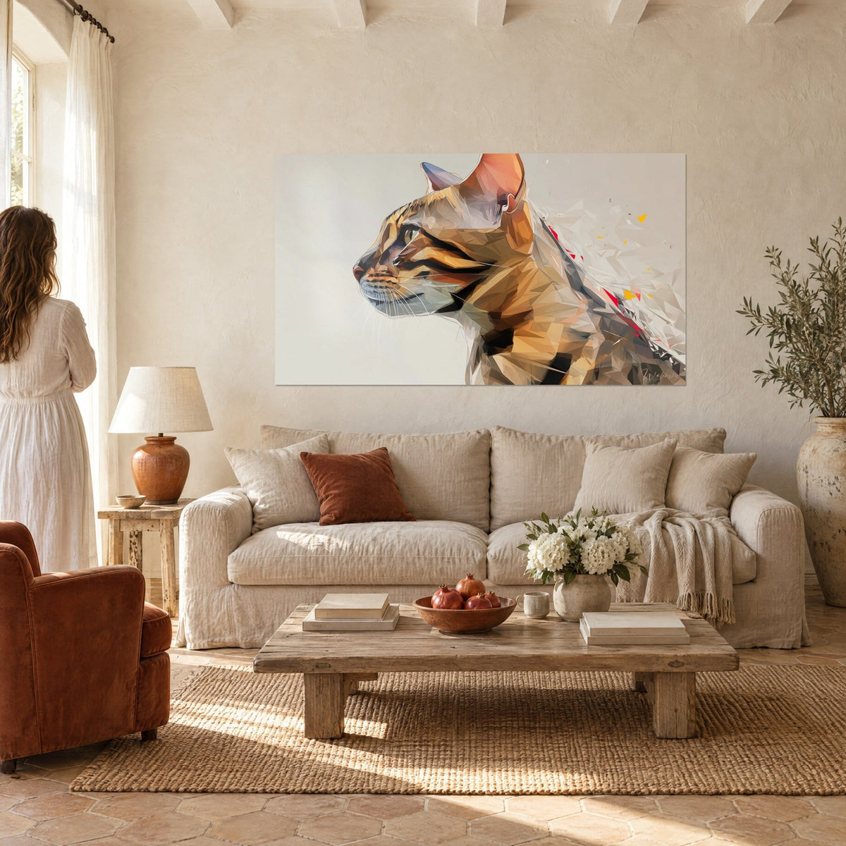 Wall art feline in profile made of ochre and orange faceted shapes, pink ear, pearl grey background, hung above a sofa in a bright living room