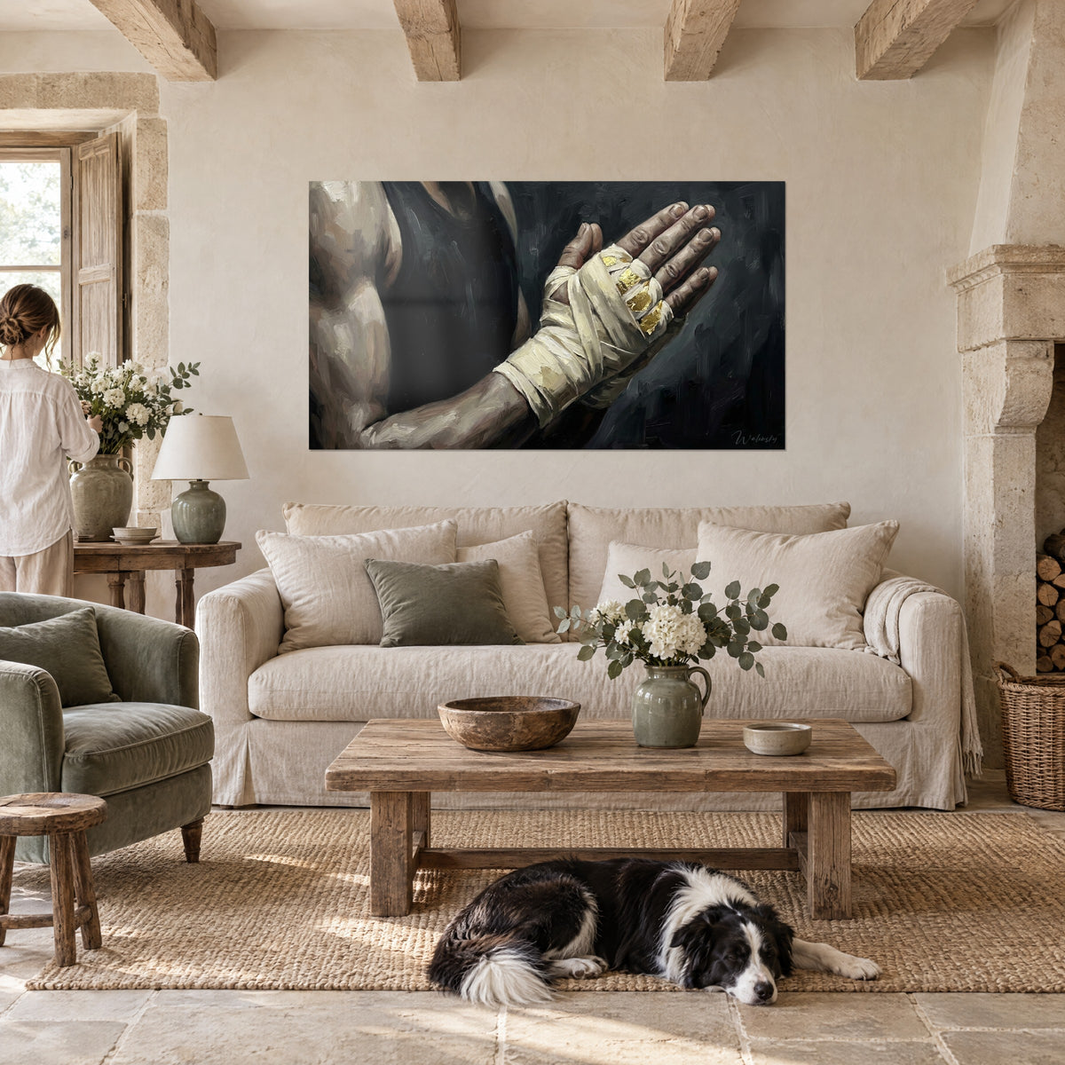 Wall art boxer's bandaged hand with gold leaf accents, cream stripes on charcoal background, a woman and a collie, above a sofa in a bright living room