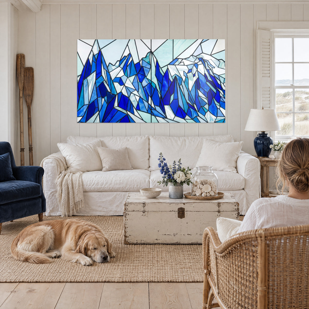 Cuadro de cimas de hielo en vidriera, azul cobalto y blanco escarchado, colgado sobre un sofá en un salón luminoso