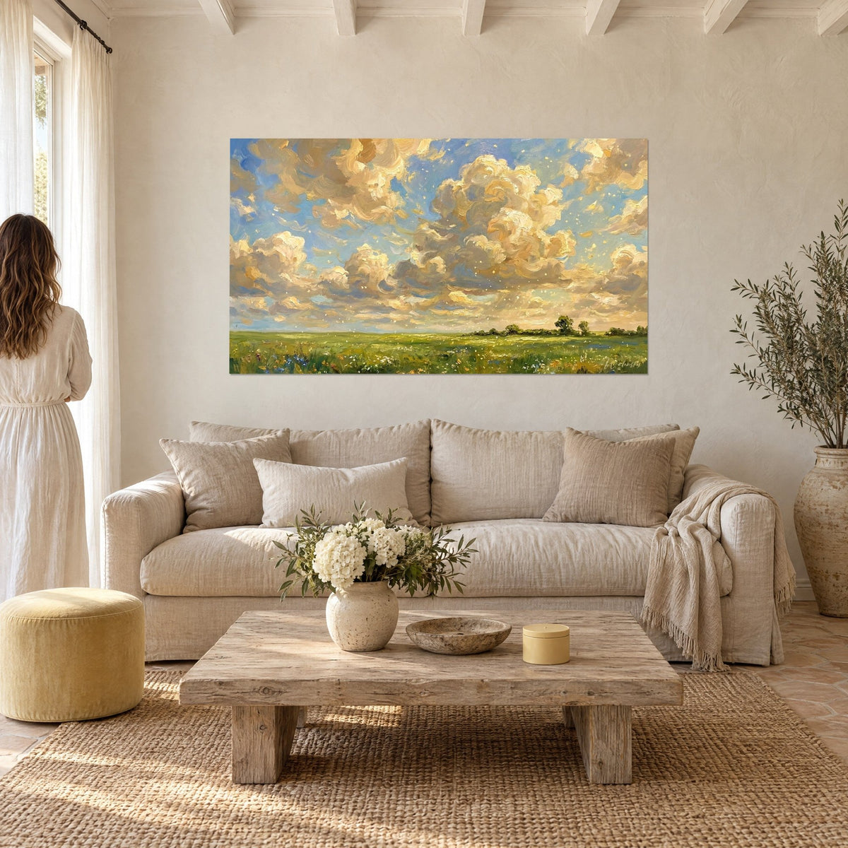Wall art summer sky with large cream cumulus clouds on a blue background, green flowering meadow, above a sofa in a bright living room