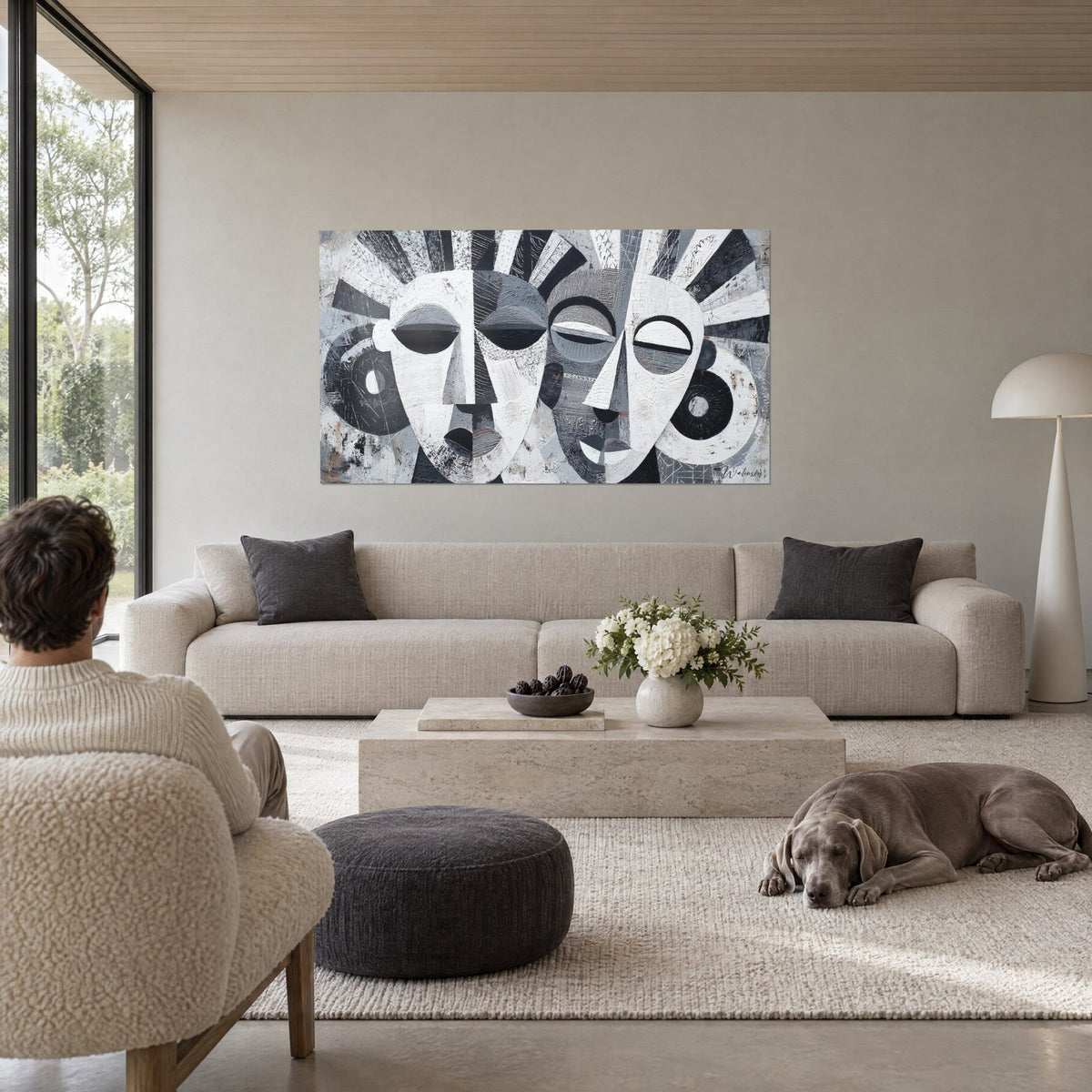 Schilderij met zwart-witte tribale maskers en grijze stralen, dikke reliëfstructuur, een persoon van achteren, Weimaraner, boven een bank in een lichte woonkamer