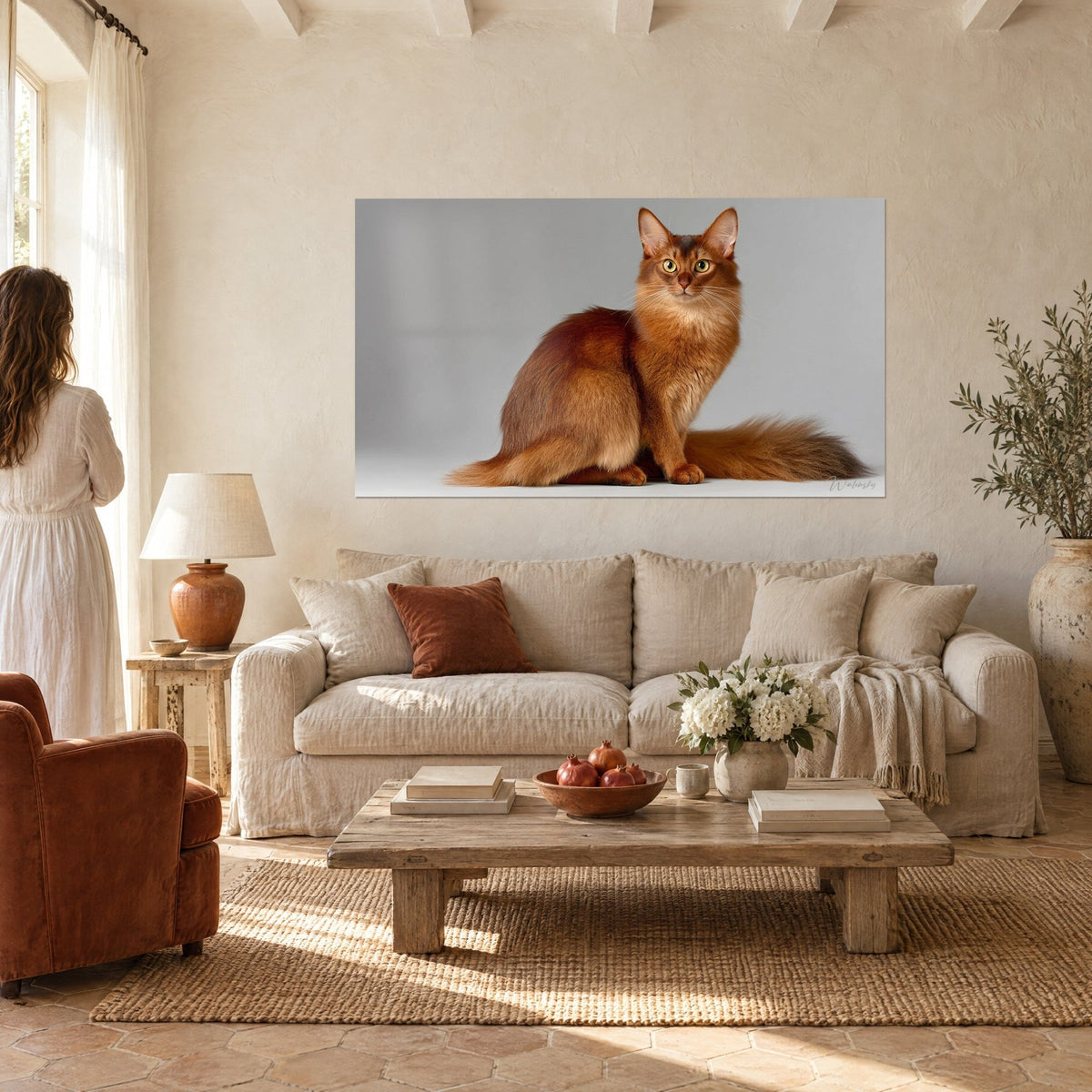 Tableau chat Somali roux assis, yeux dorés en alerte, fond gris perle, au-dessus d'un canapé dans un salon lumineux