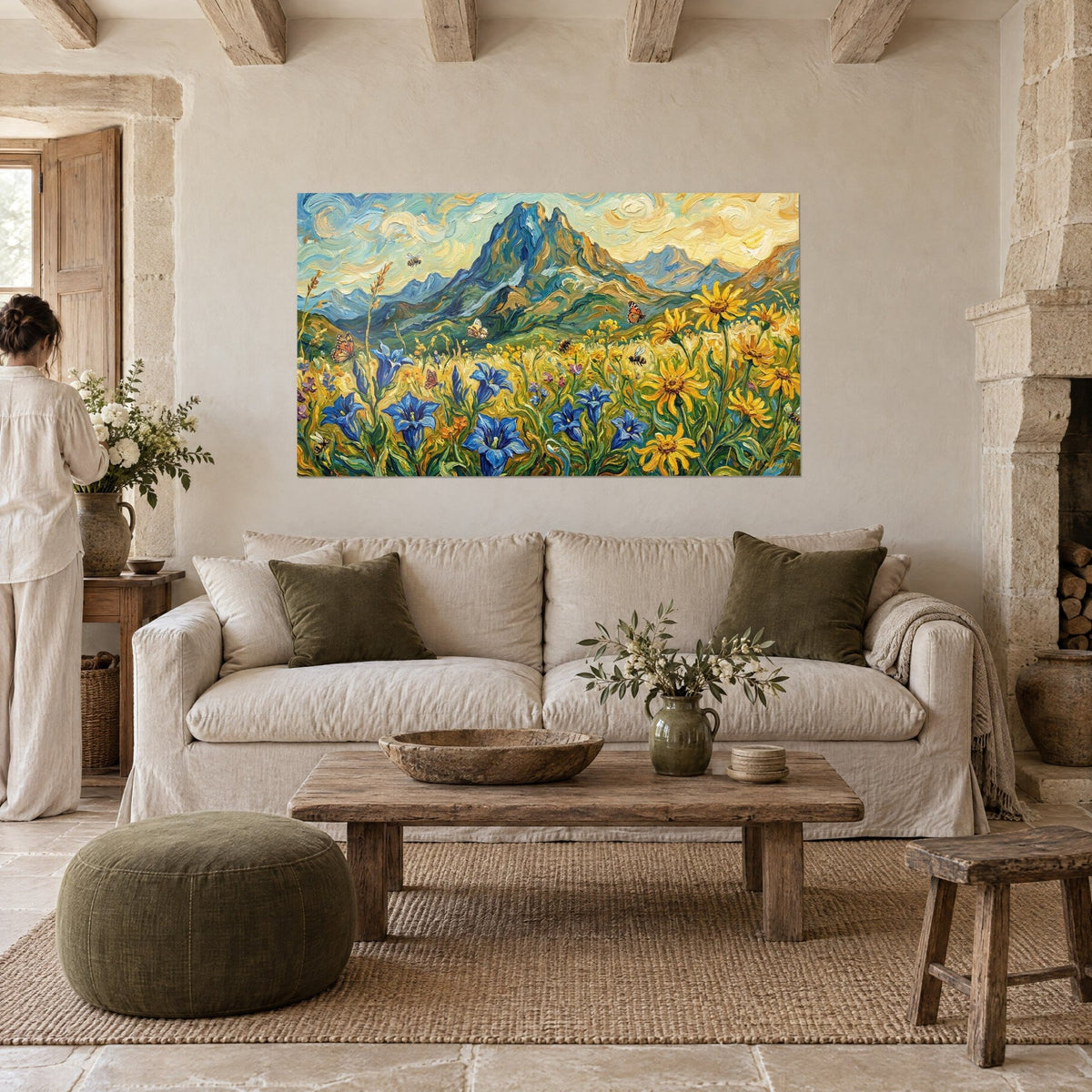 Schilderij van een Pyreneese bergtop met dikke blauwe en groene penseelstreken, indigokleurige gentianen en gele zonnebloemen, boven een bank in een lichte woonkamer