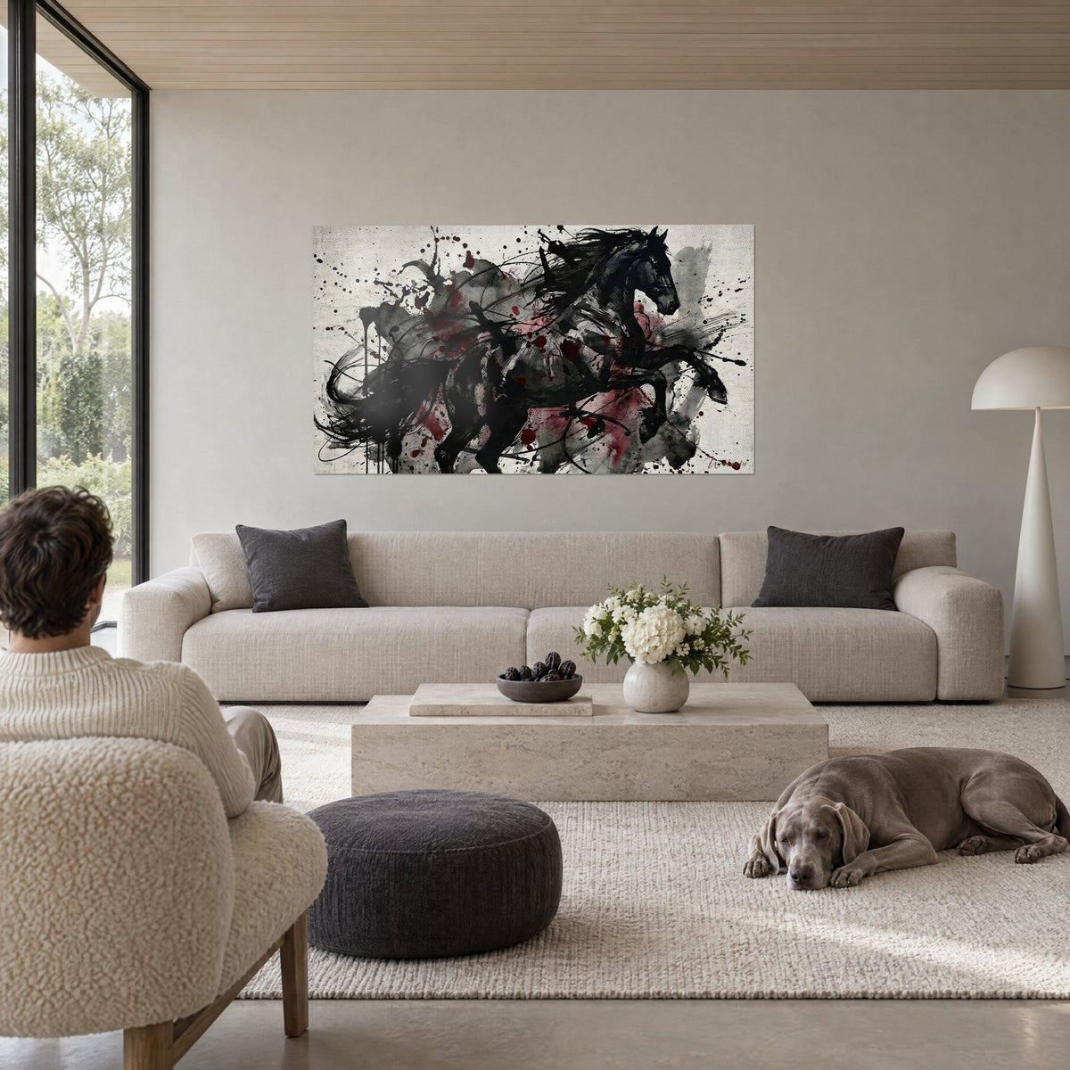 Wall art black horse in full gallop, blood-red splashes on a cream background, above a sofa in a bright living room